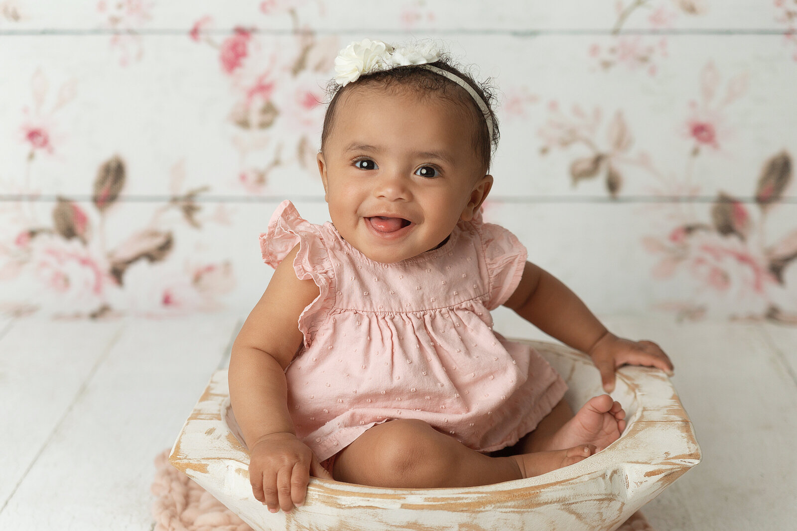 little girl smiling in bowl with flower background