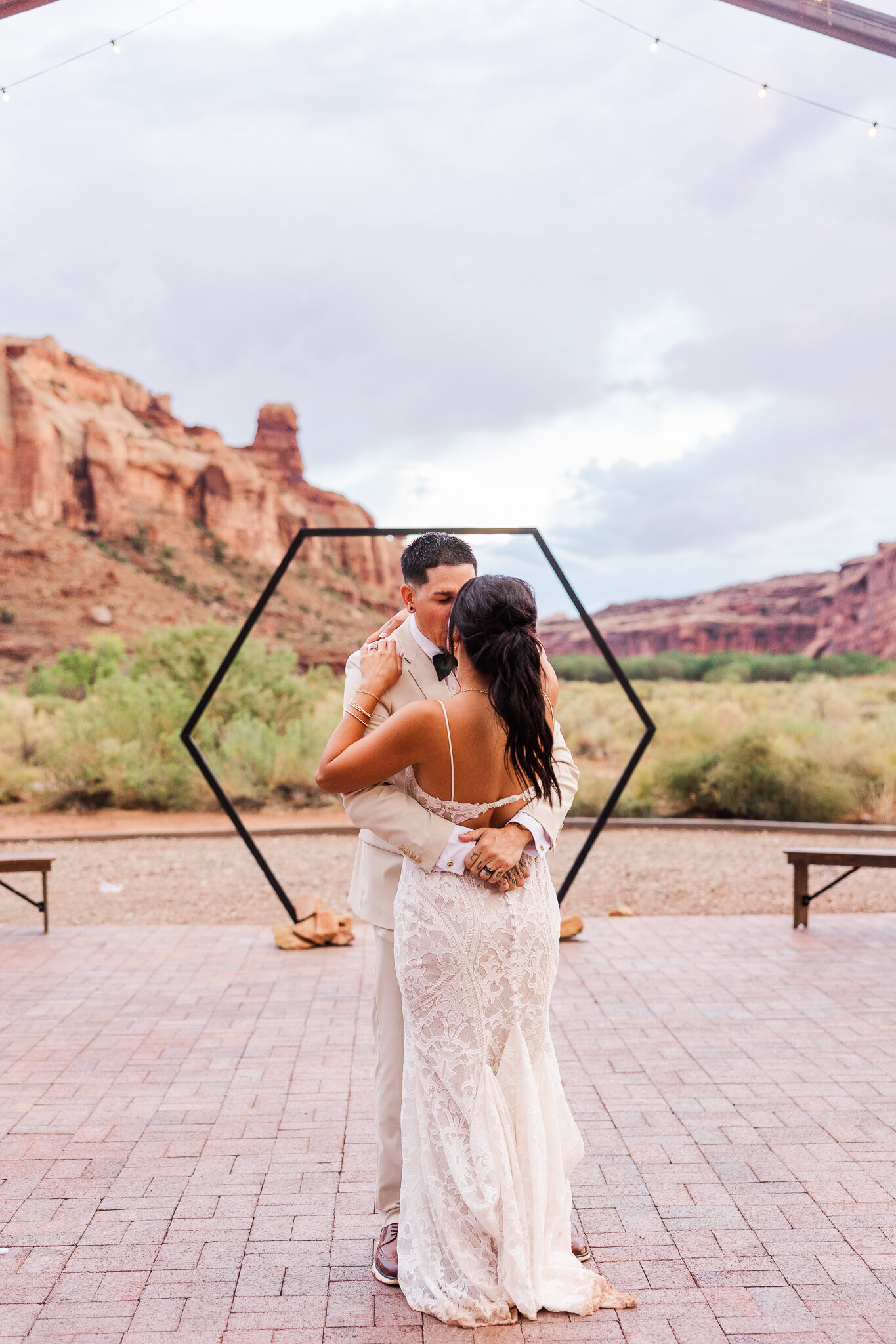Bride and groom share their first dance with the red earth venue mountains in the background