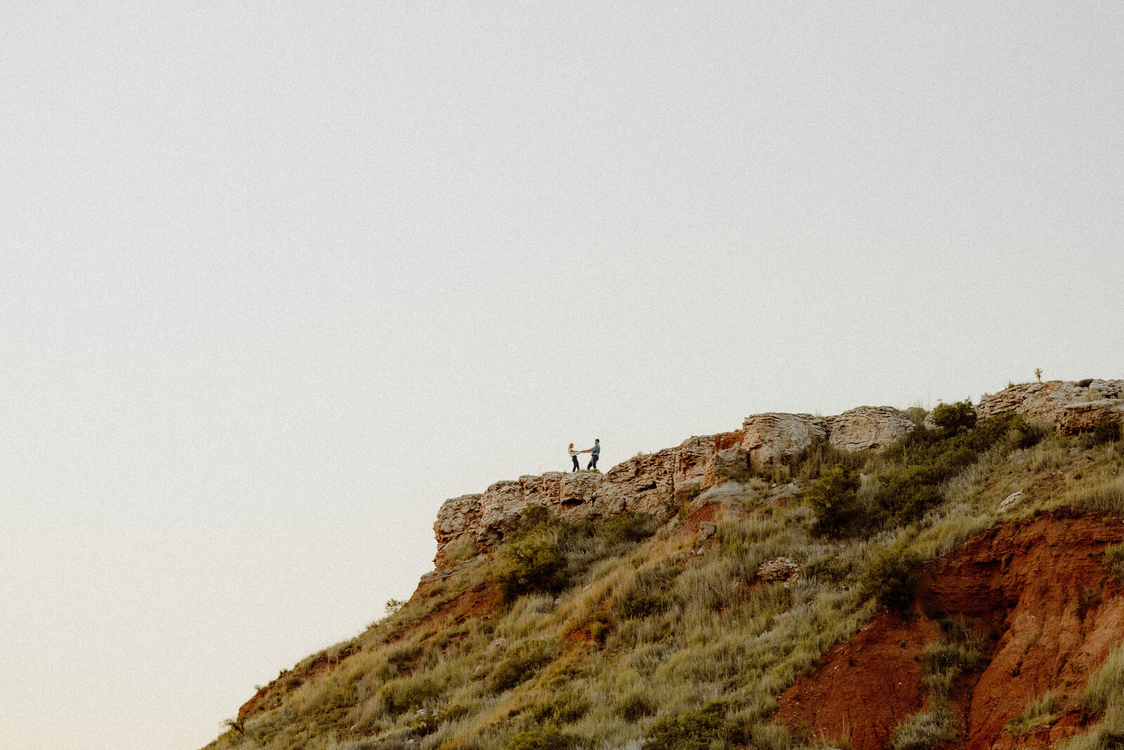 okc wedding photographer documents couples engagement photo on top of a cliff