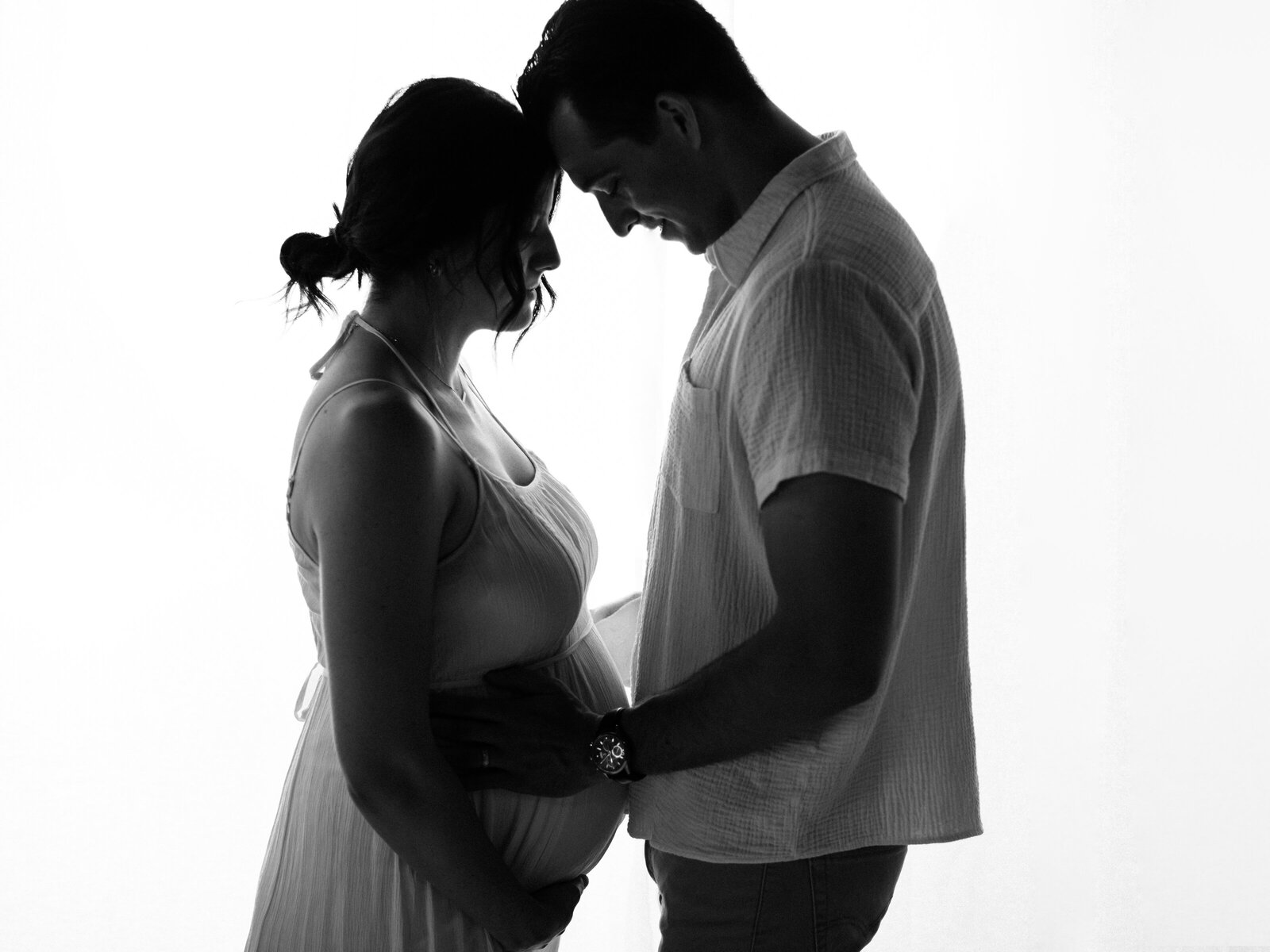husband and wife holding pregnant belly for maternity photoshoot
