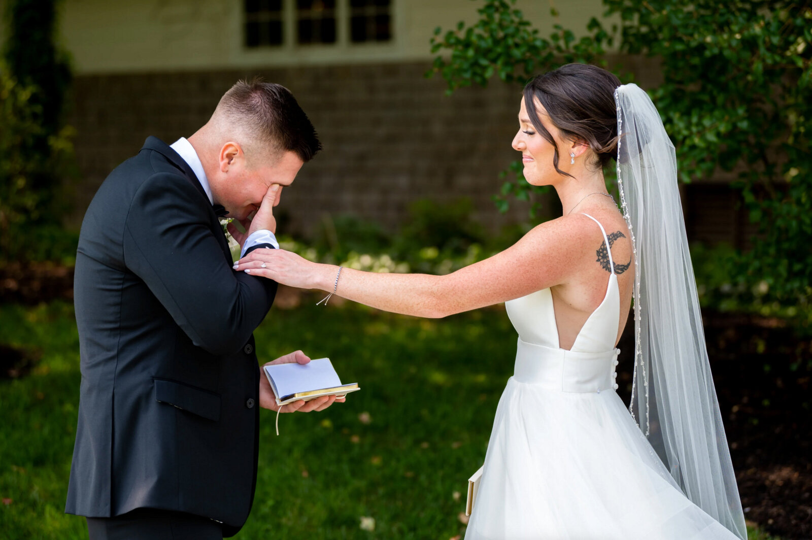 Groom, crying with the bride, holding his arm, while he recites his vows during their first look outside of Atlantic City country club