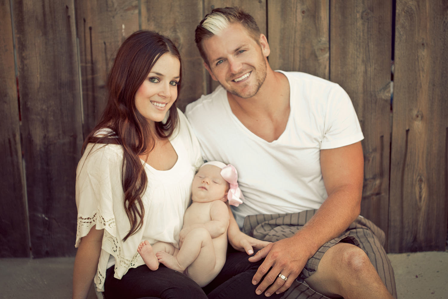 san diego newborn photography | newborn with parents in backyard with wood fence