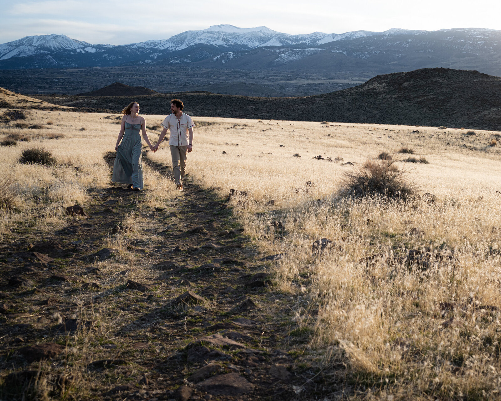 couple walking a dirt road at sunset in south reno