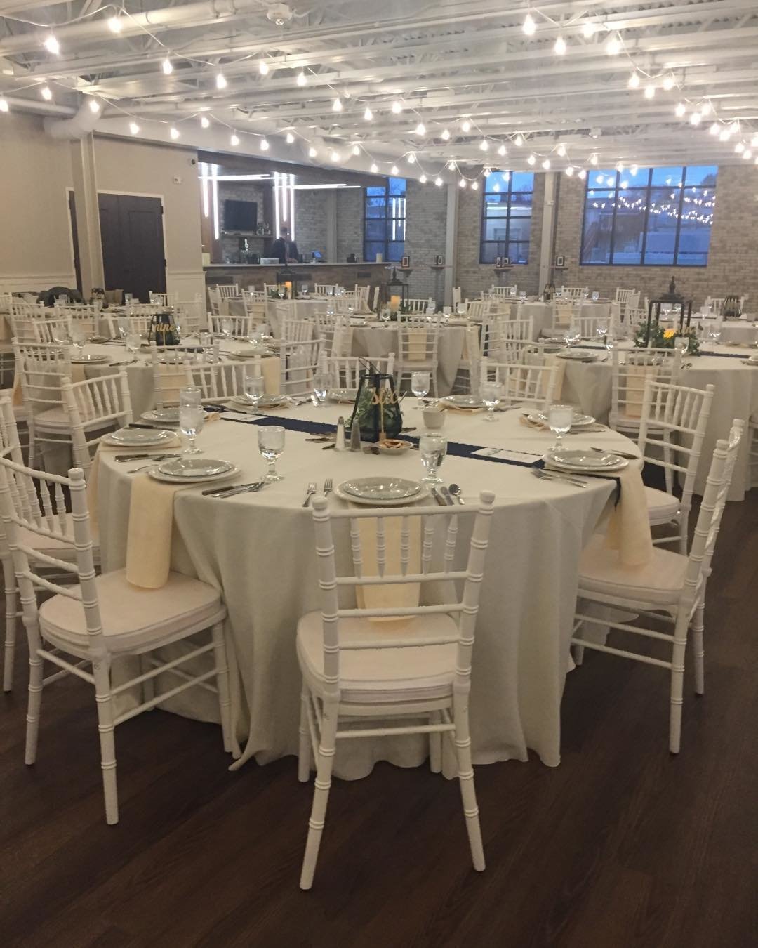 White tables and chairs set up for a wedding