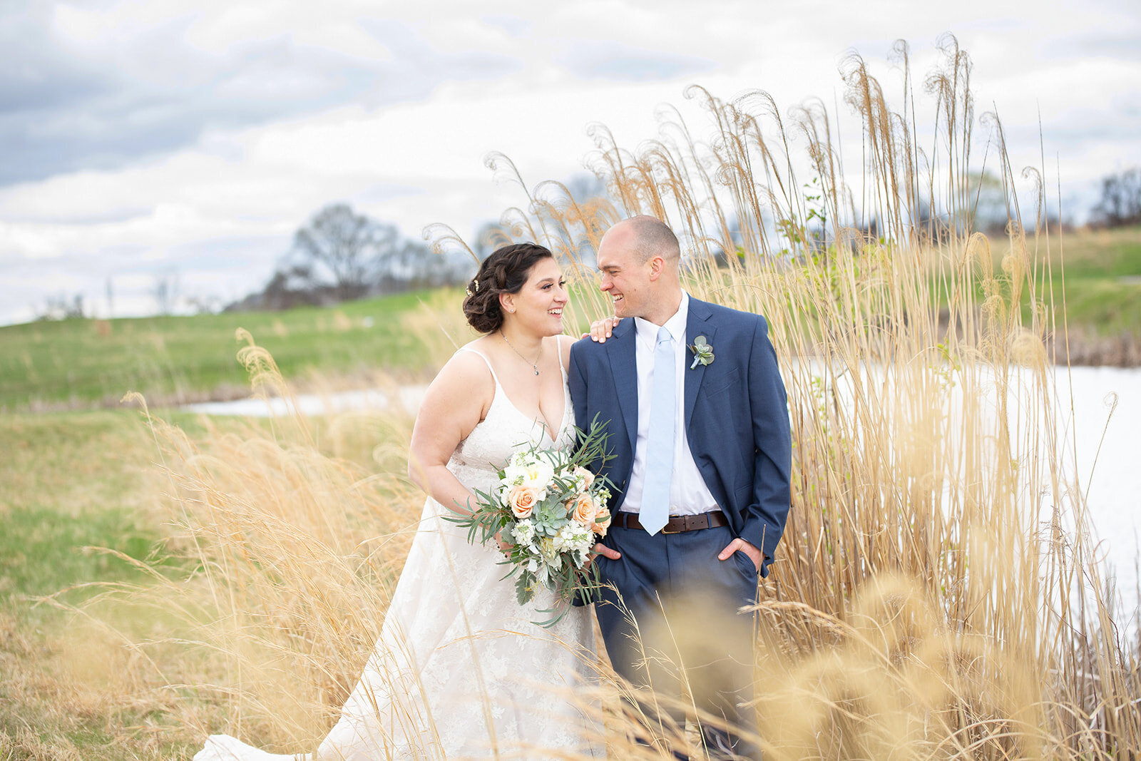 bride and groom in a field for their portraits