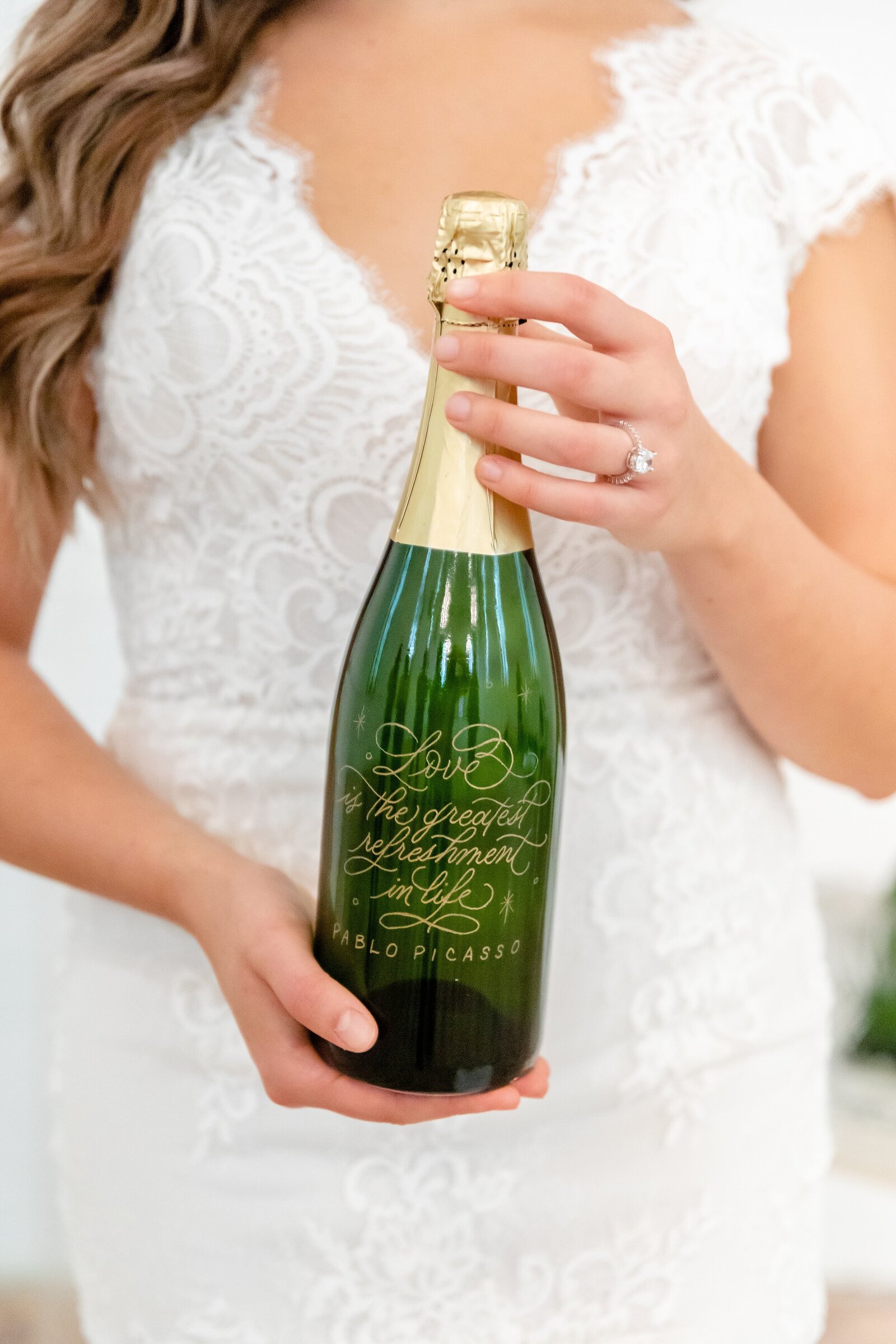 Bride-holding-wedding-champagne-bottle-at-la-petite-chapelle