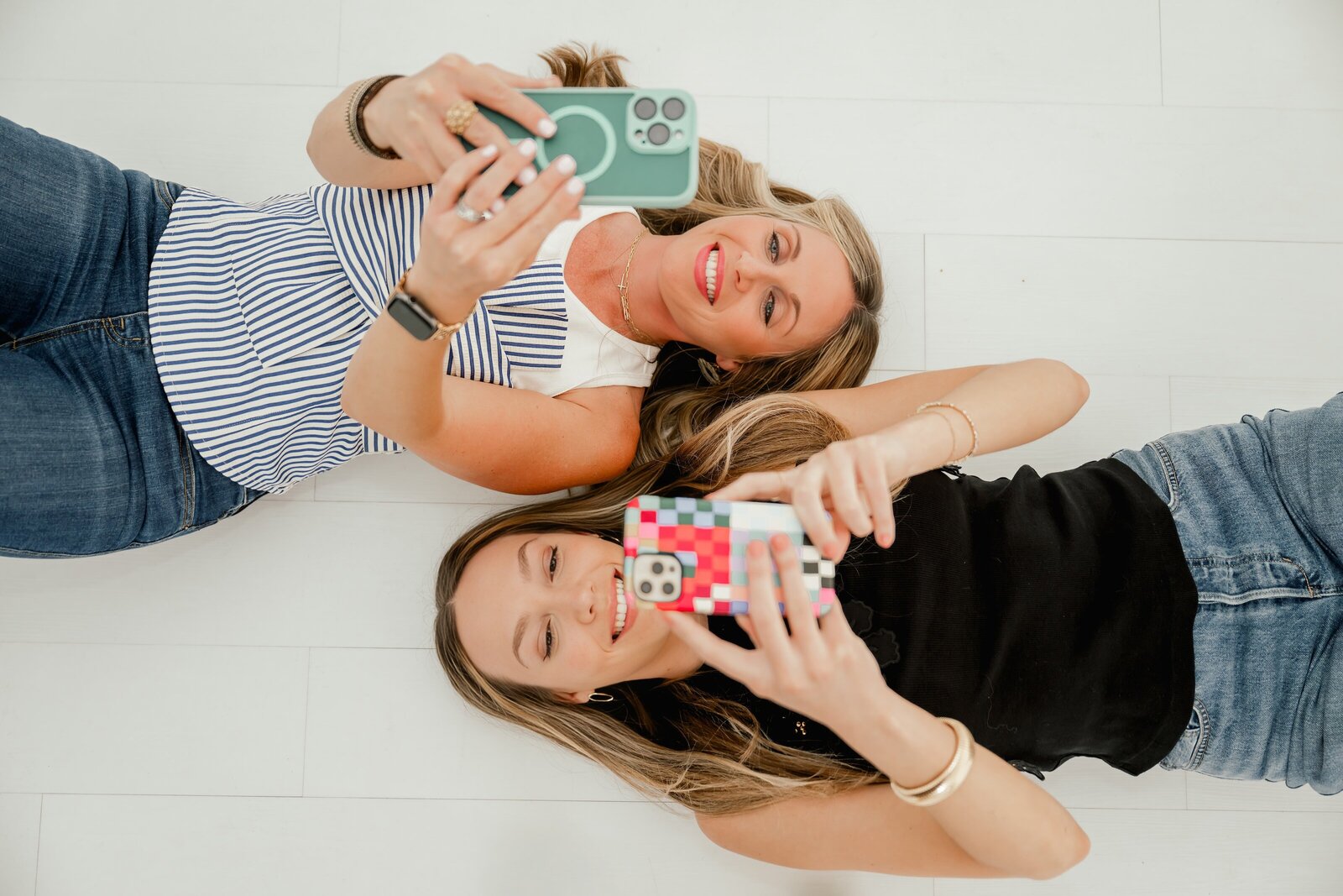 CP2 Group posing for branding photos looking at phones laying on their back 