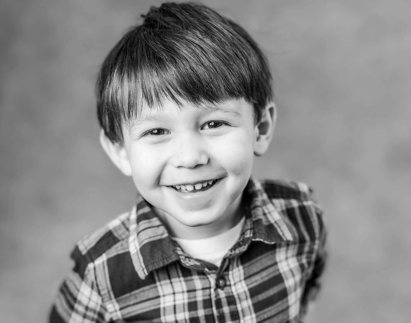 A child in a plaid shirt smirks.