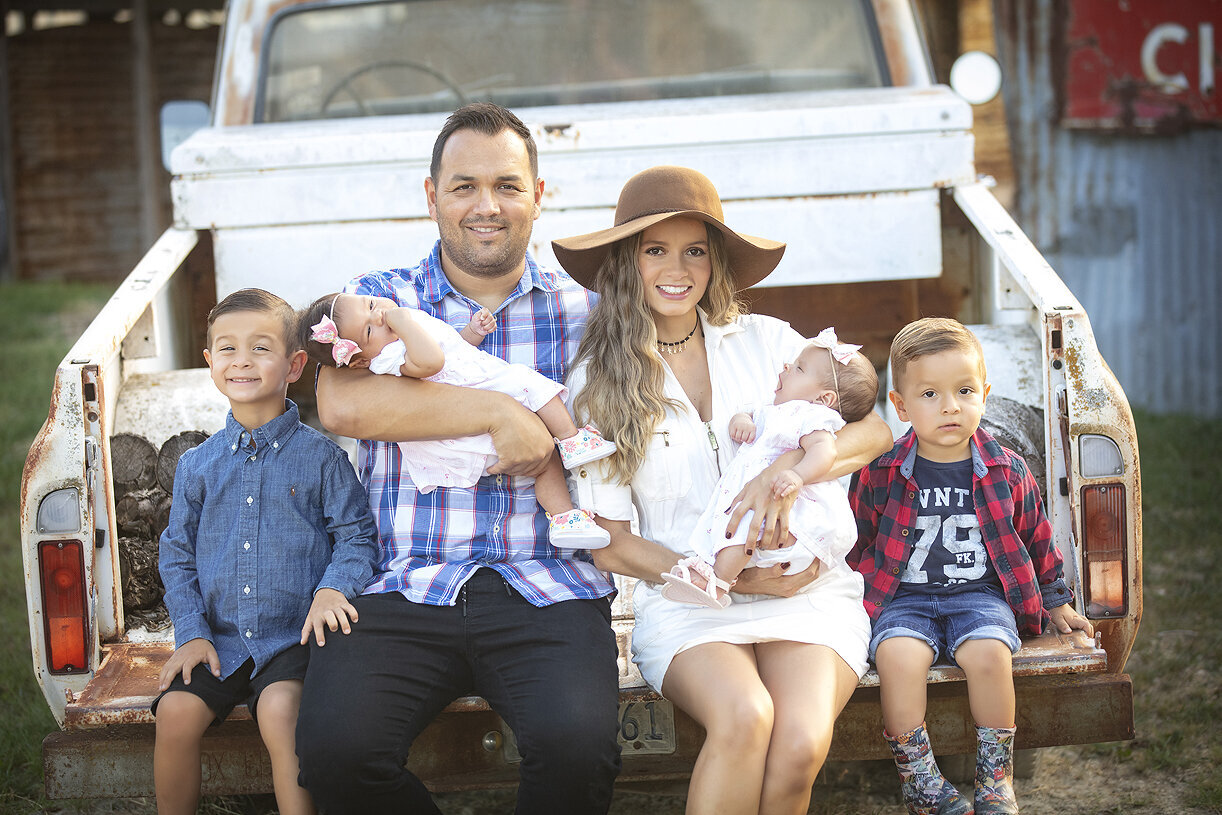 Family sitting in back of truck at Luscombe Farms.