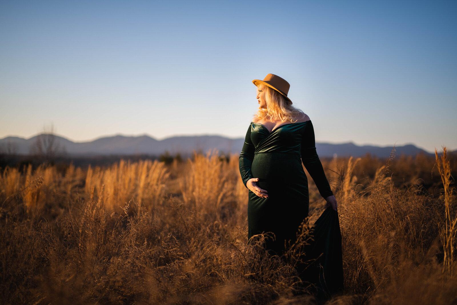 Maternity photos in Knoxville mom holding belly in mountains
