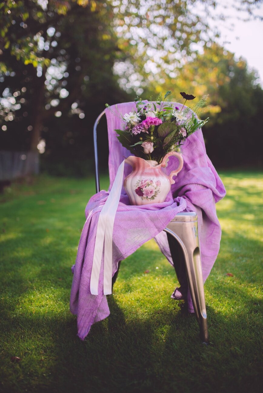bouquet on chair with purple linen