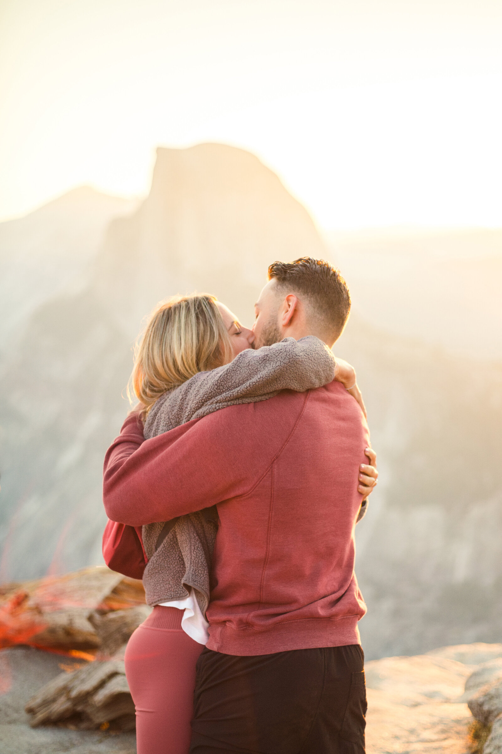 A wedding proposal between two hikers at sunrise in front of Half Dome in Yosemite National Park.