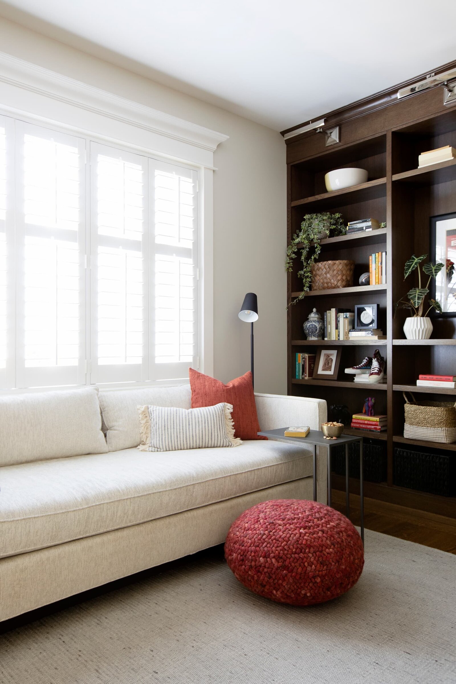Granville Project l Den-Reading Room l Neutral Sofa with Red Pouf and Black Reading Lamp