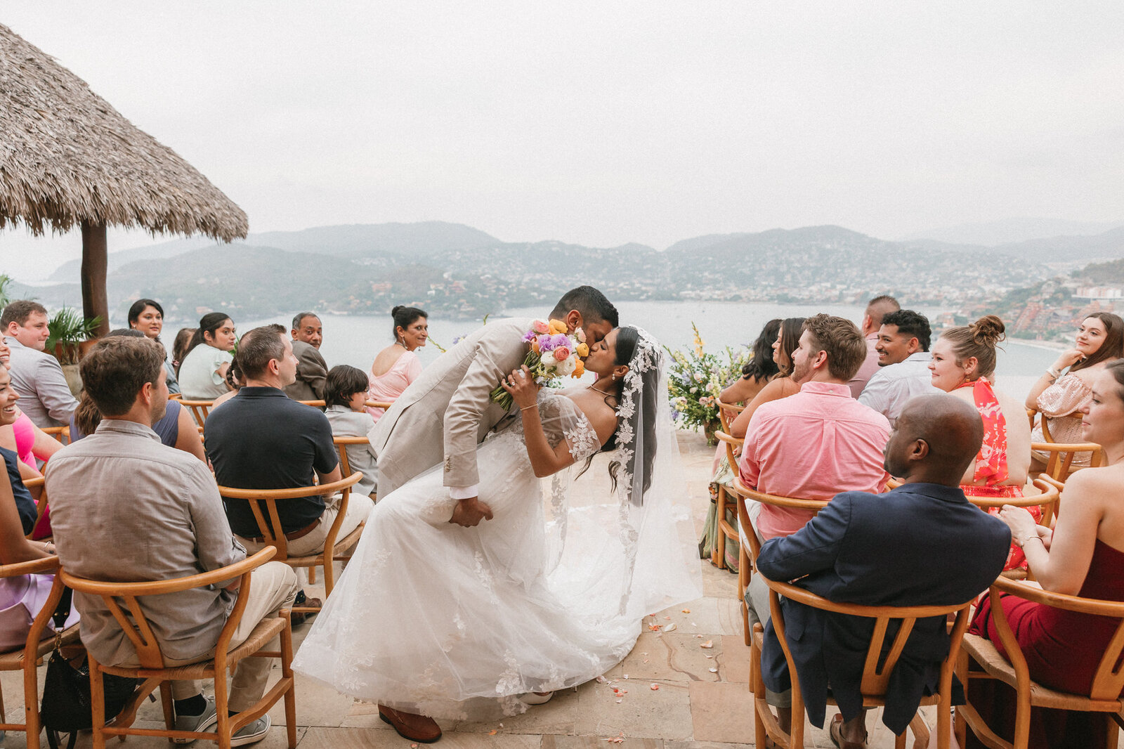 Groom dipping bride for a kiss at ceremony at Casa Angelina in Zihuatanejo, Mexico