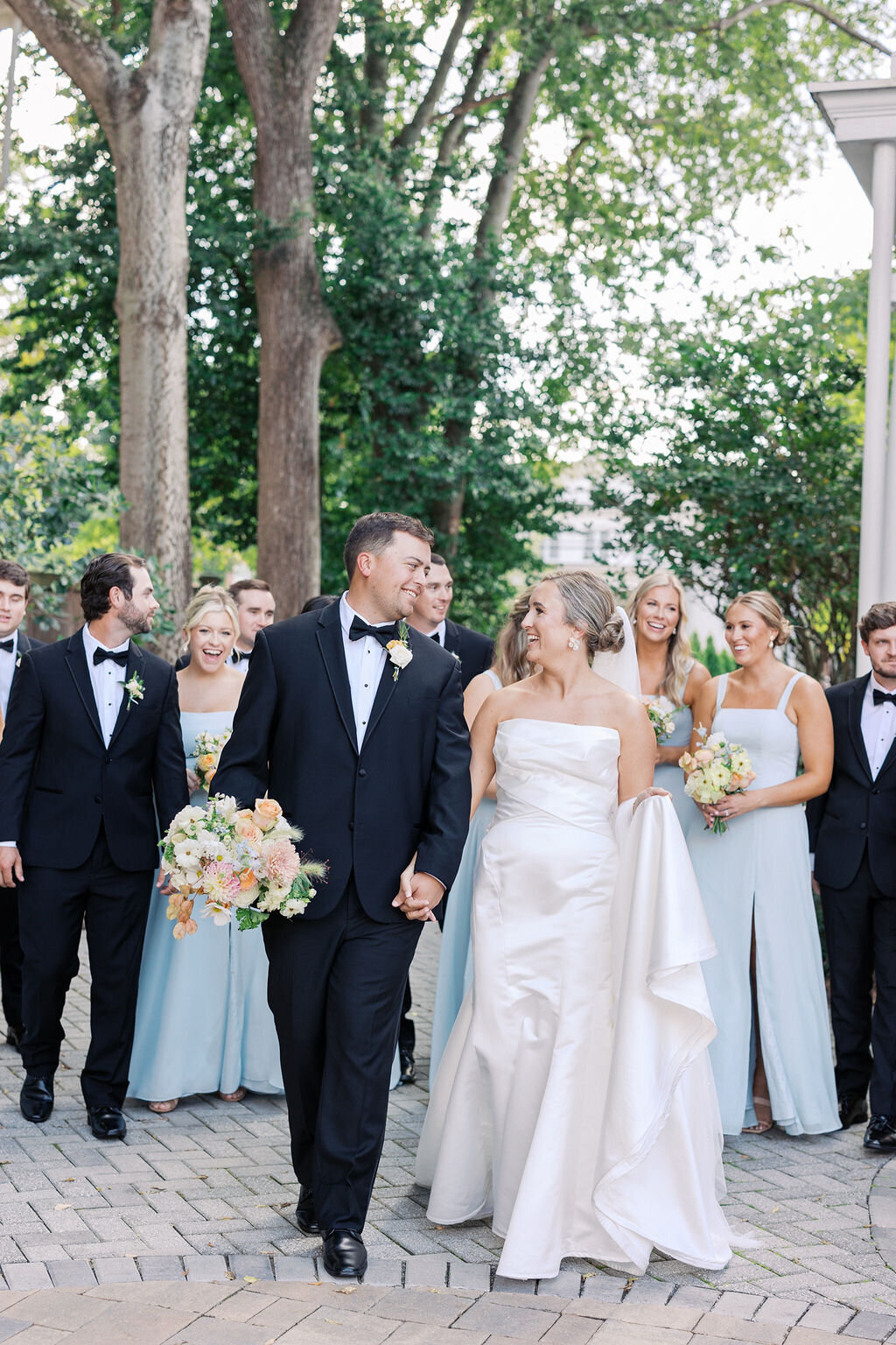 Bride groom and wedding party stand outside of 255 Milledge