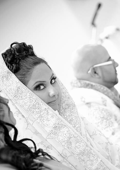 Indian bride in Ottawa radiates joy, adorned in vibrant lehenga and jewelry, makeup by Red Carpet Glamour