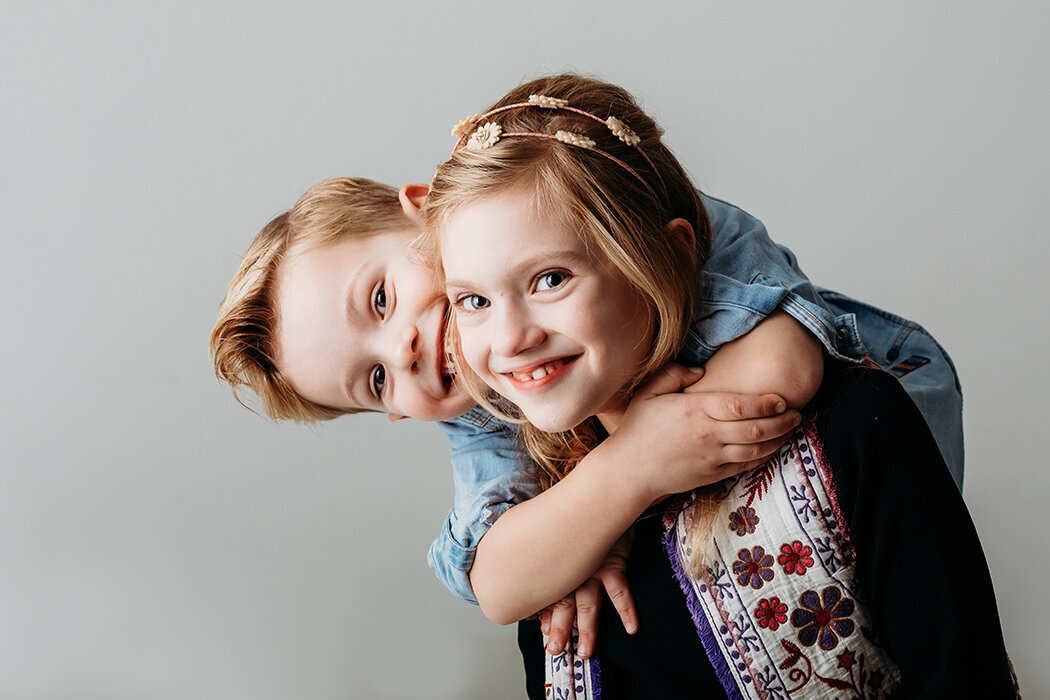 Broer en zus kinderportret studio lichte achtergrond. jpg