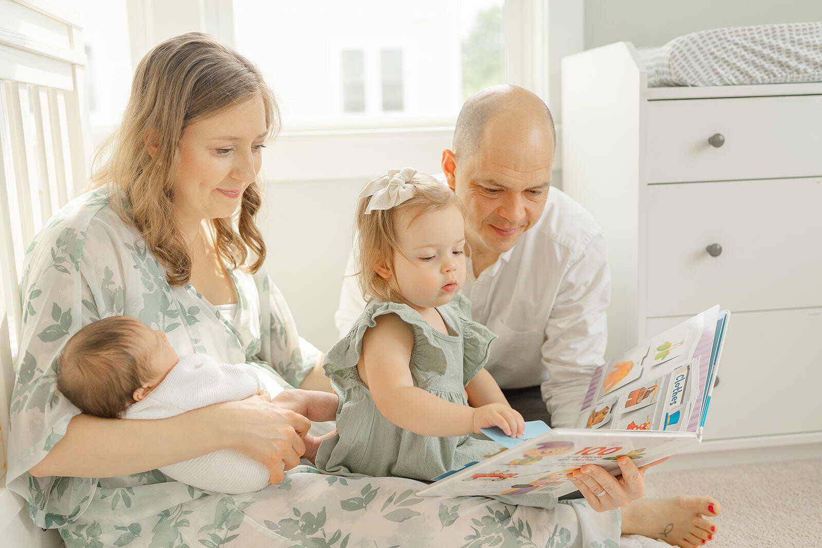 big sister reading a book during Haymarket, VA newborn photo