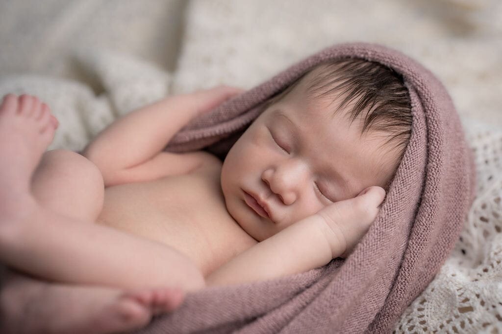 Baby girl sleeps contently throughout her newborn photography session in Lynnwood Wa.