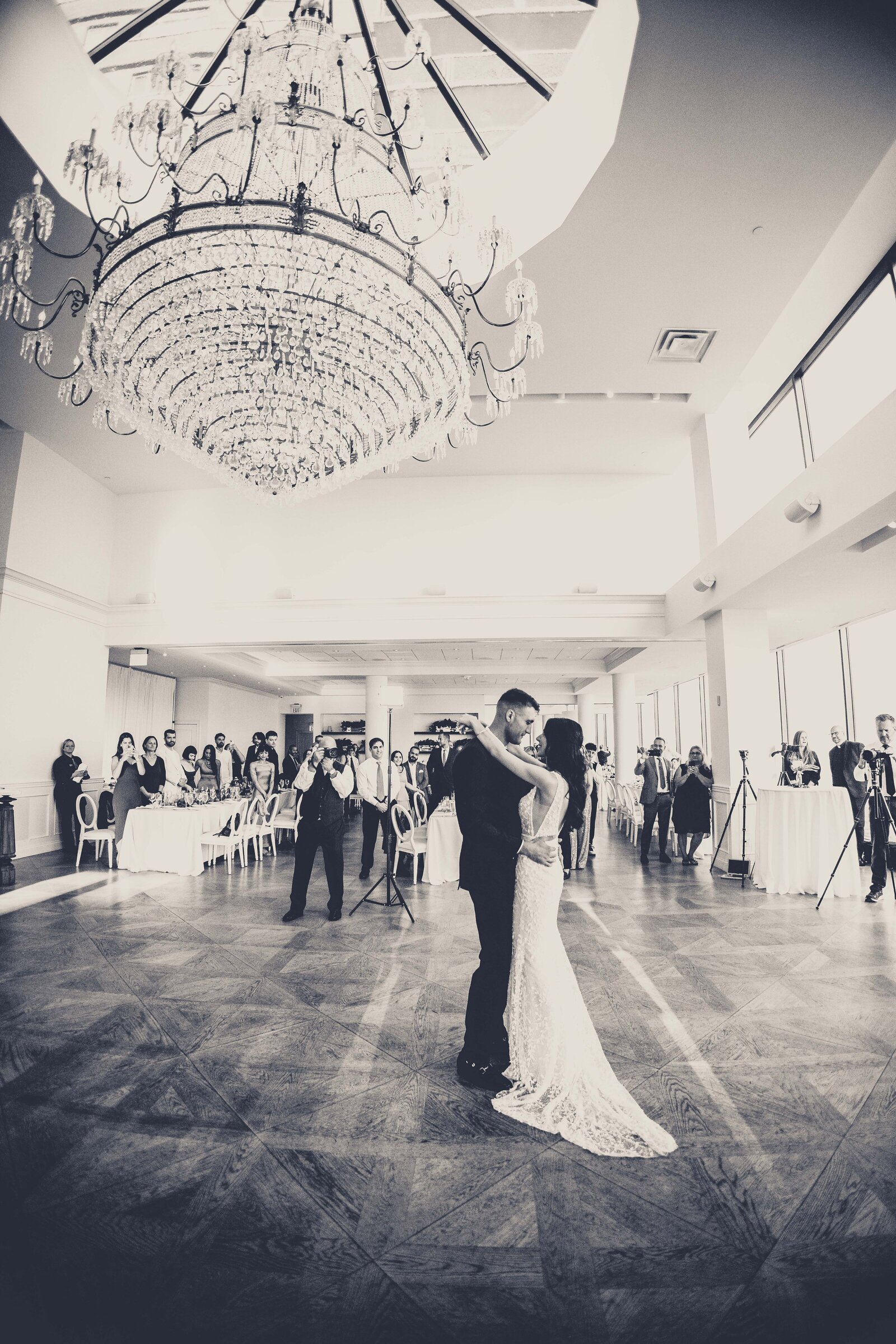 Step into the grandeur of a spectacular first dance captured from a wide-angle perspective at The View. This breathtaking photograph showcases the bride and groom in the midst of their dance, enveloped by the expansive elegance of the venue. The wide-angle shot emphasizes the scale and beauty of the setting, highlighting the couple's intimate moment amidst the stunning decor and spacious surroundings. Ideal for couples looking for inspiration on capturing the majesty and romance of their first dance in a grand venue.