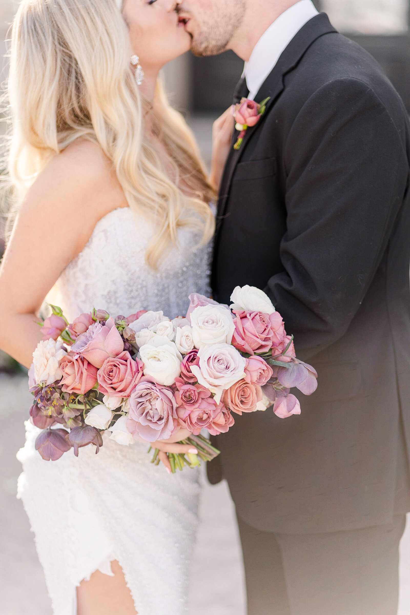 a bride shows off her bouquet as she kisses her groom, by adrienne and dani photography, napa wedding photographers