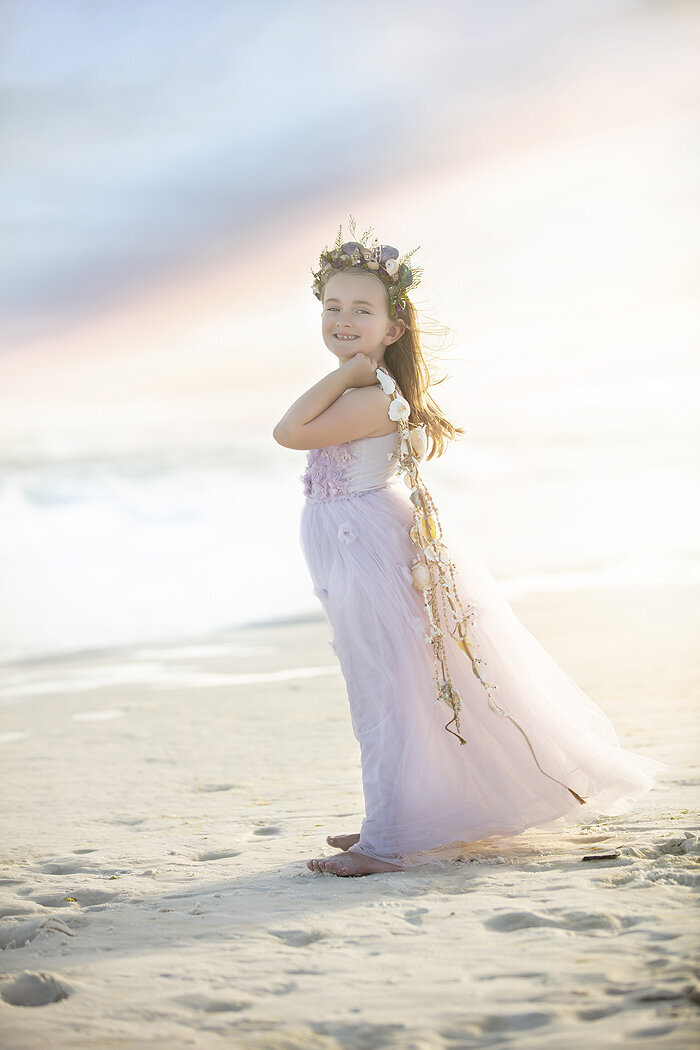 Young girl on the beach posing for a photo.