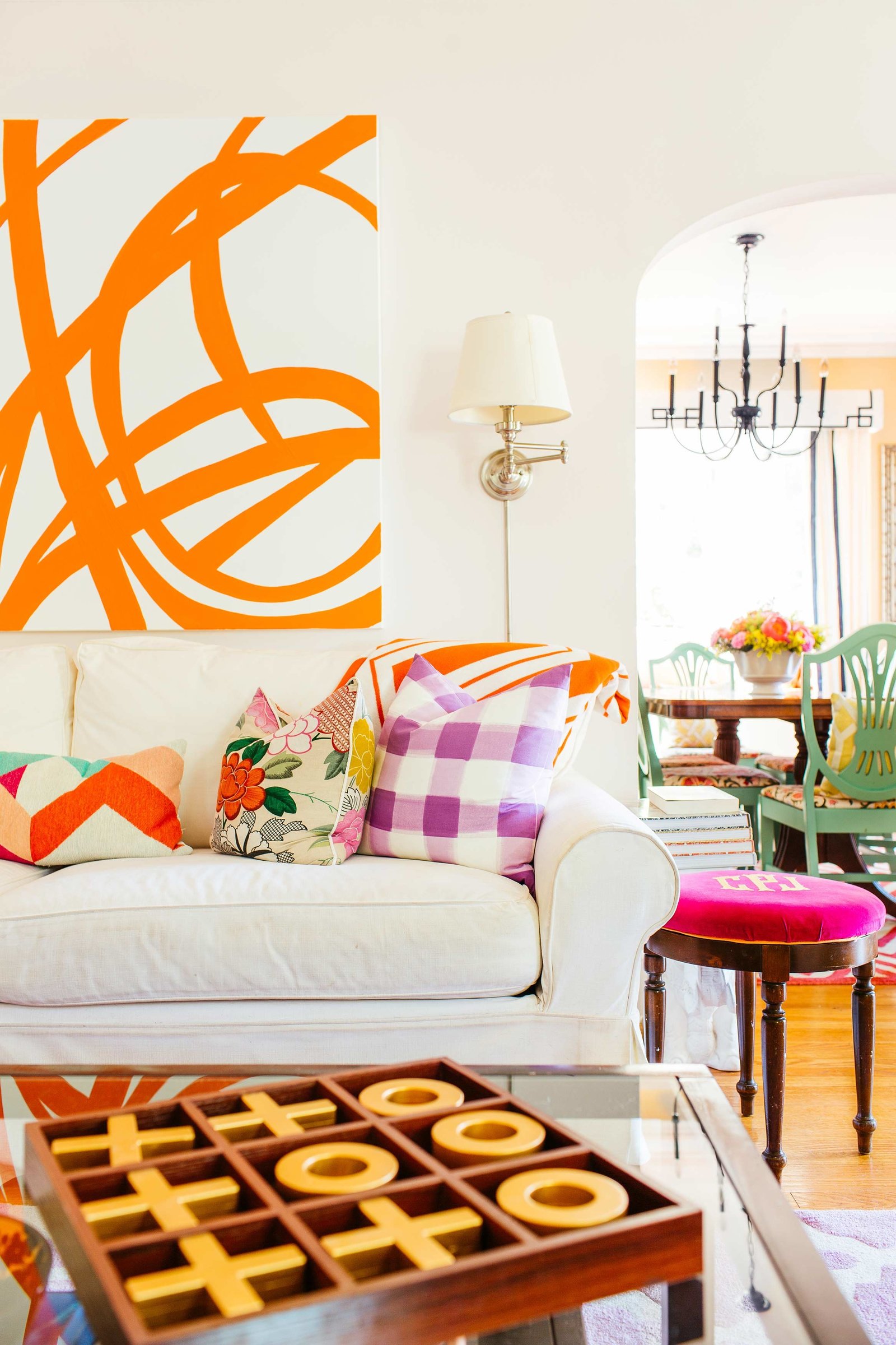 A living room with a large orange and white abstract painting.