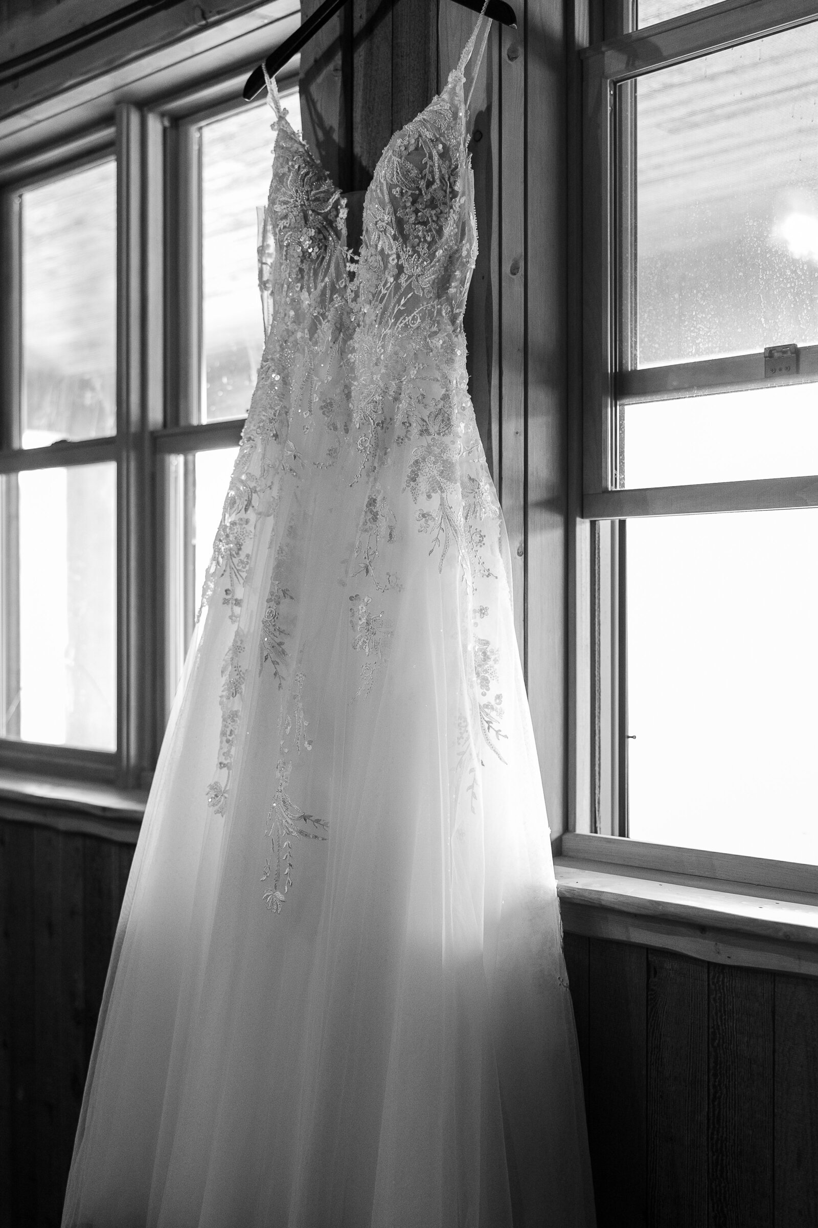 Black and white image of wedding gown hanging int he cabin at Arrowhead Lodge