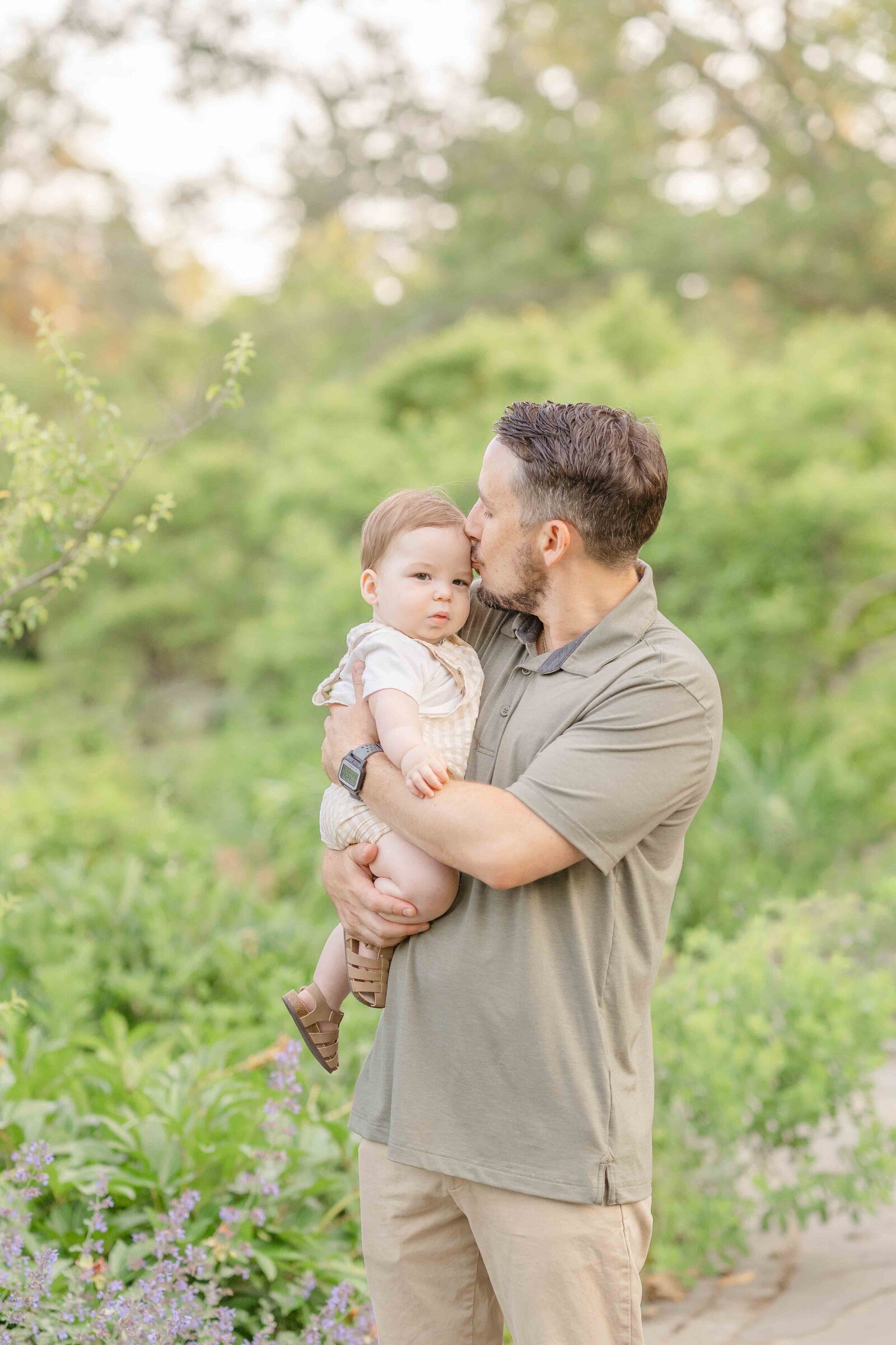 dad kissing son during spring mini session in Chantilly, Virginia