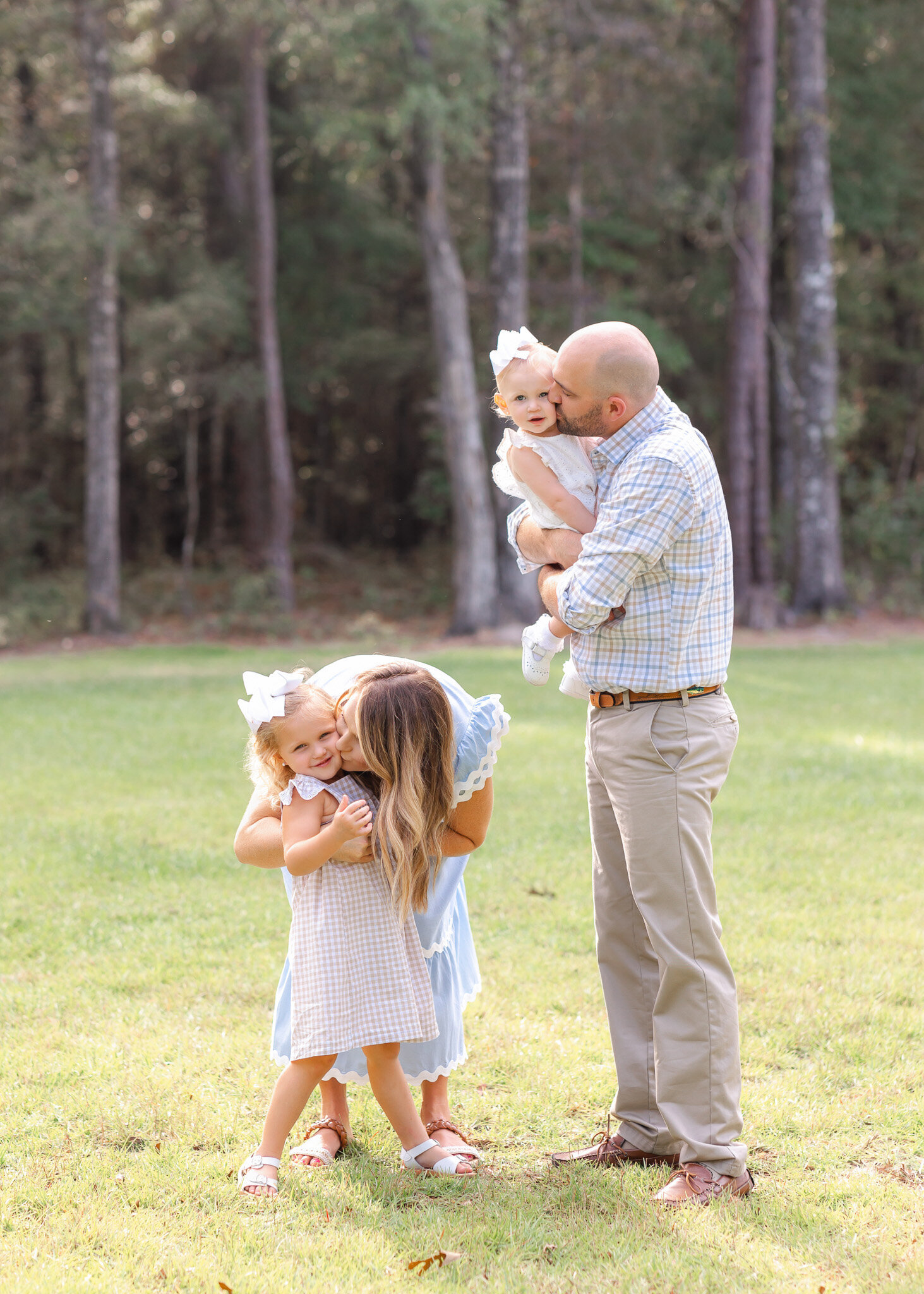 mom and dad loving on their daughters at their photoshoot in Savannah, Ga