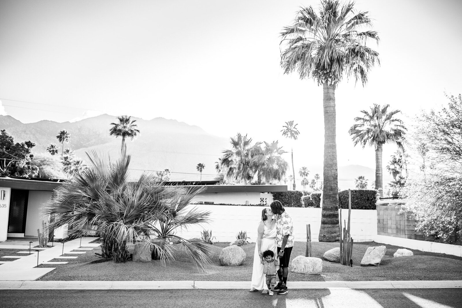 Black and white image of family standing in front of modern Palm Springs home.