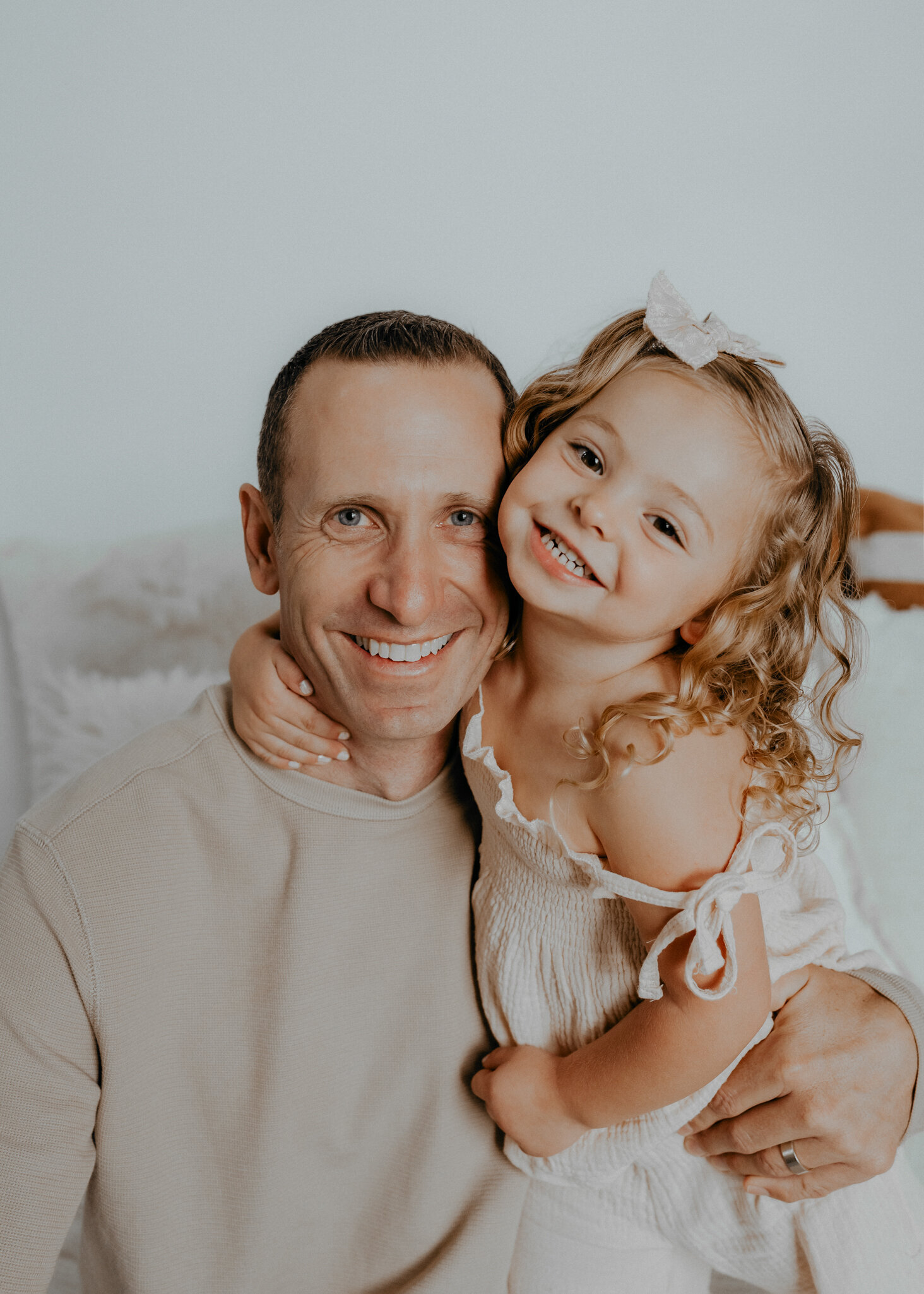 A father cuddles up next to his daughter.
