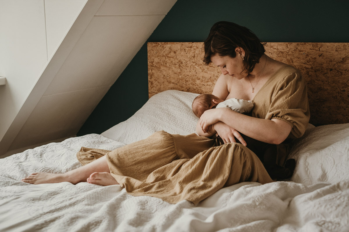 moeder die haar baby borstvoeding geeft op bed