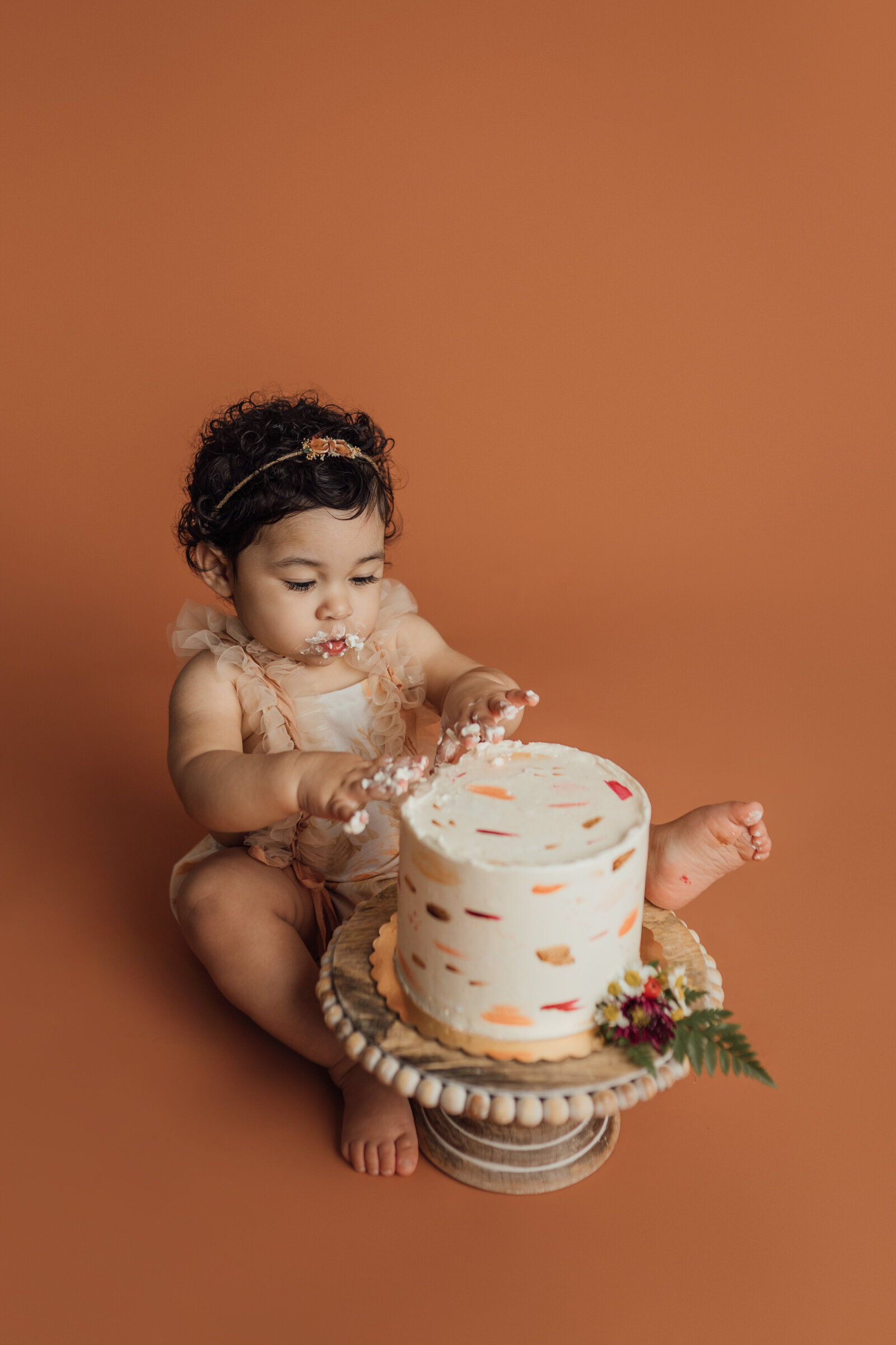 girl eating cake during first birthday photography session in St. Pete