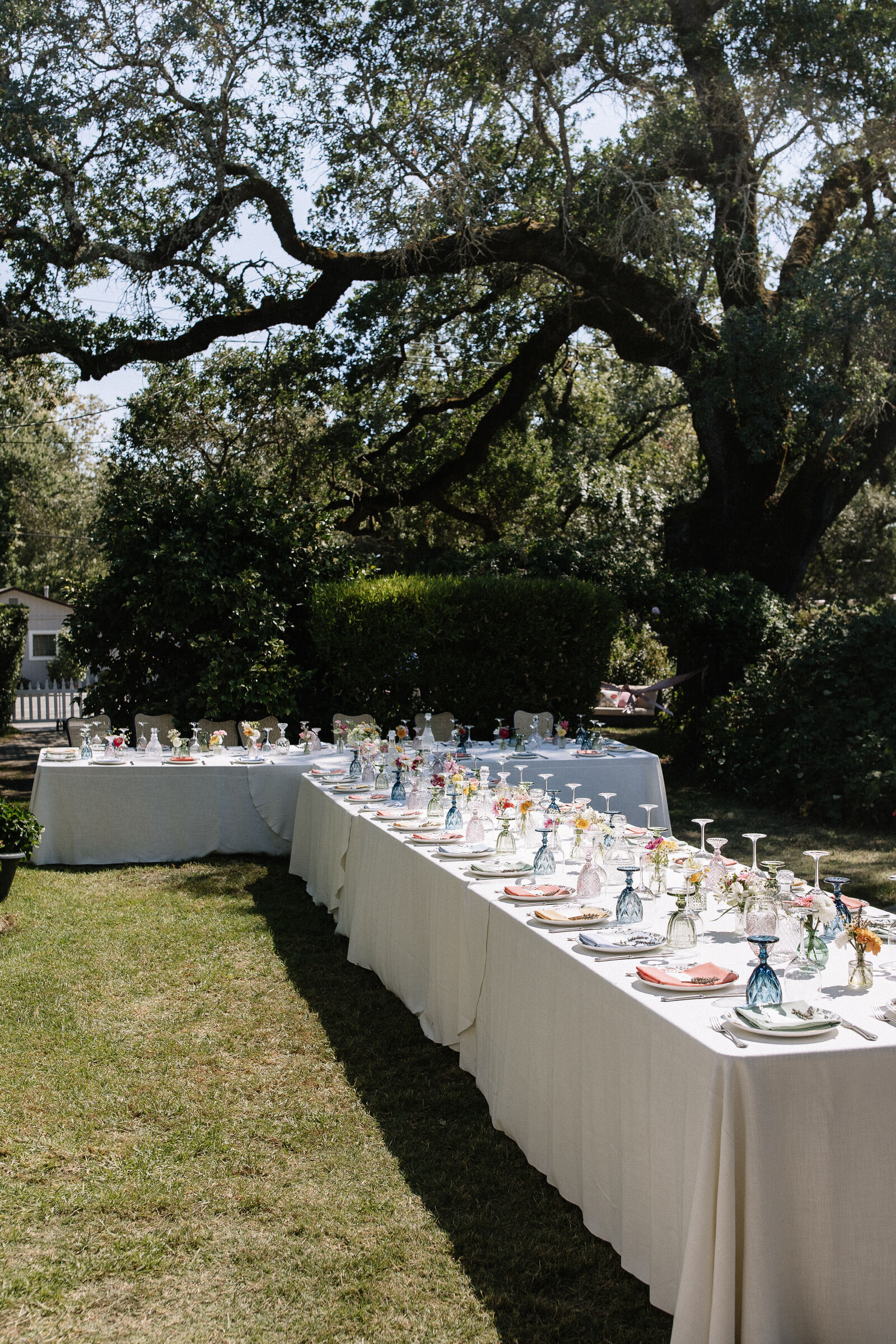 Outdoor Idaho wedding reception tables filled with colorful napkins, glasses, and florals