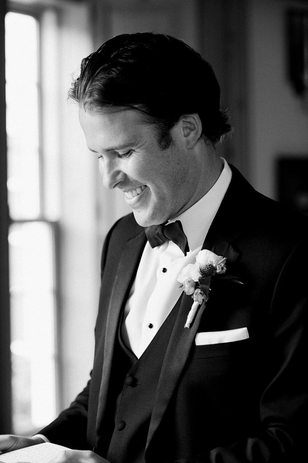 groom closeup smiling reading note