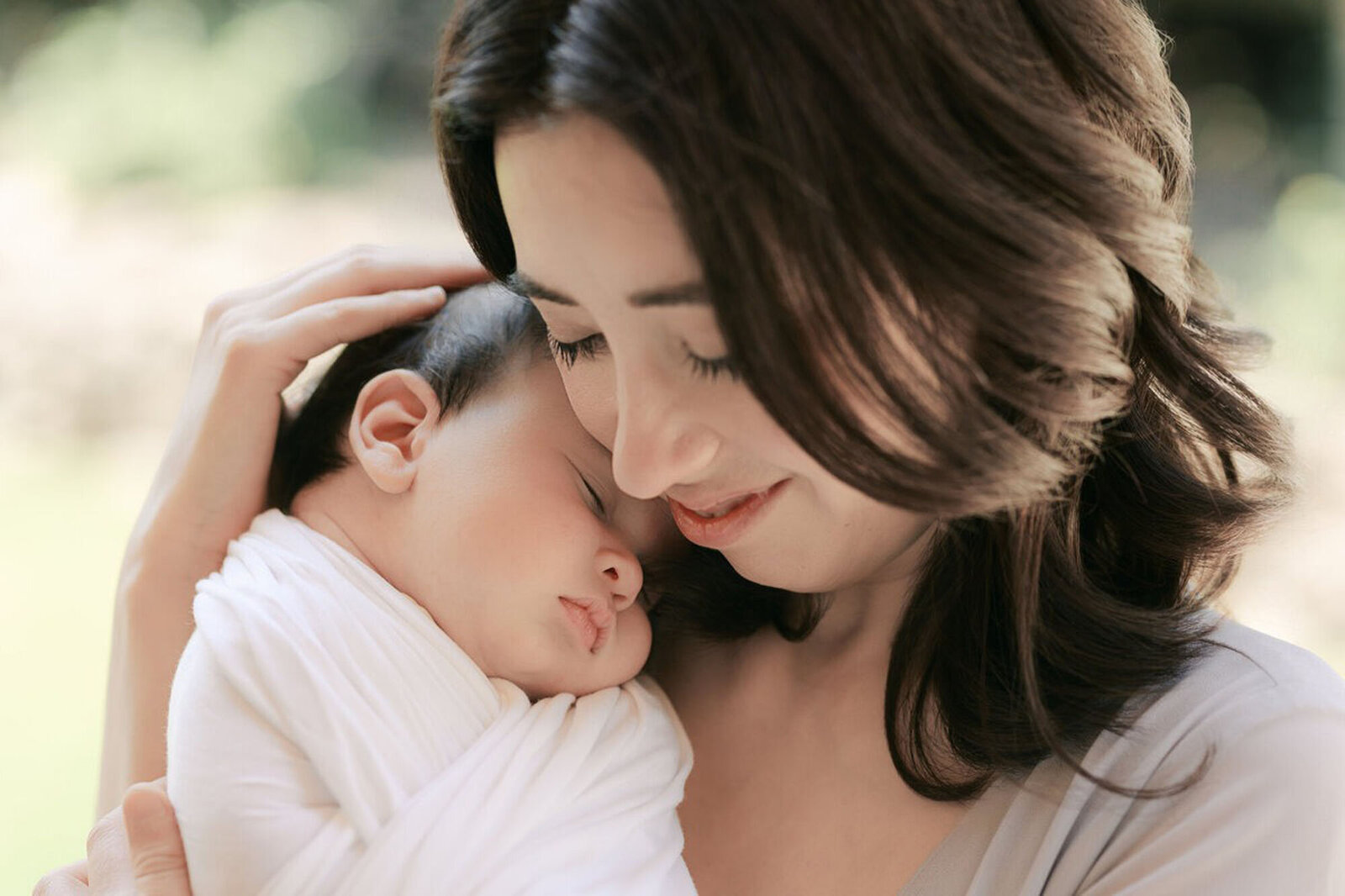 Newborn baby swaddled and asleep on mom's chest, taken by Laurel Smith, Bay Area newborn photographer.