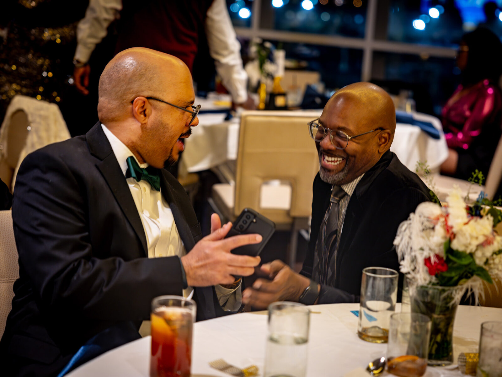 two men talking and laughing at an event
