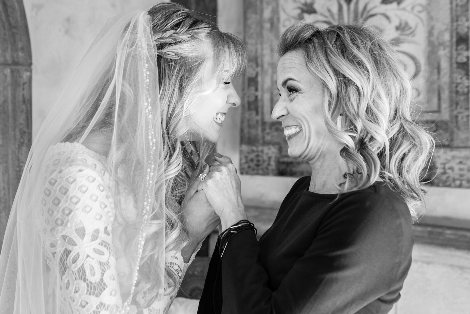 Bride and her mom sharing an excited moment while getting ready before the wedding.