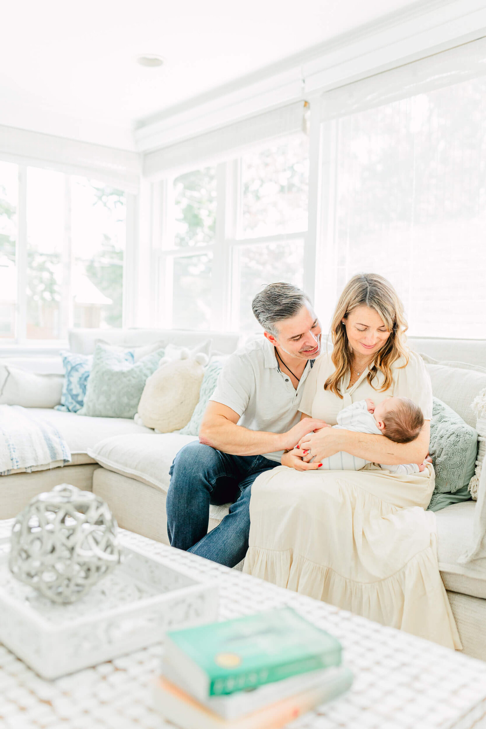 Mom and dad gazing at their newborn on a couch