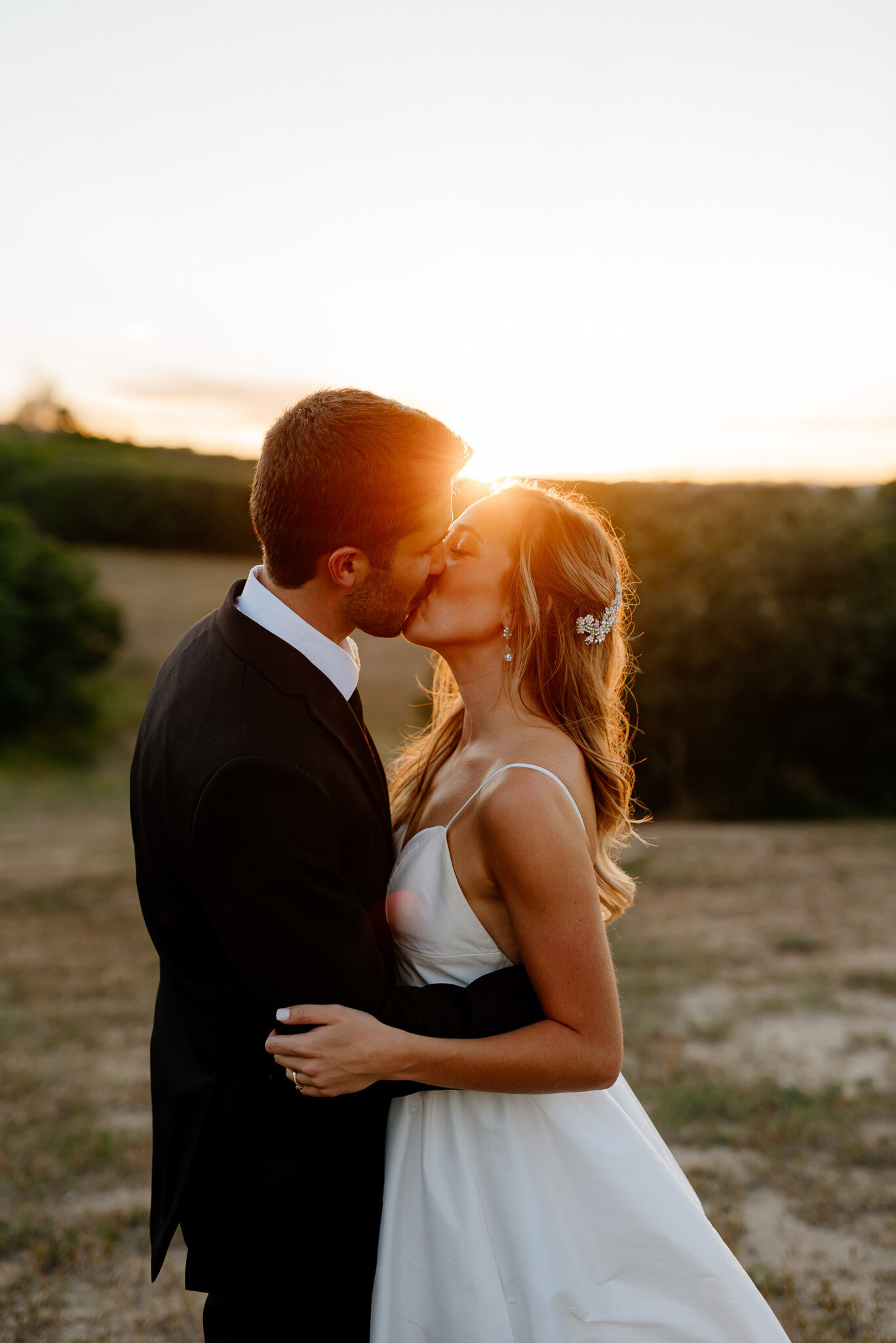 bride and groom kissing at their outdoor wedding