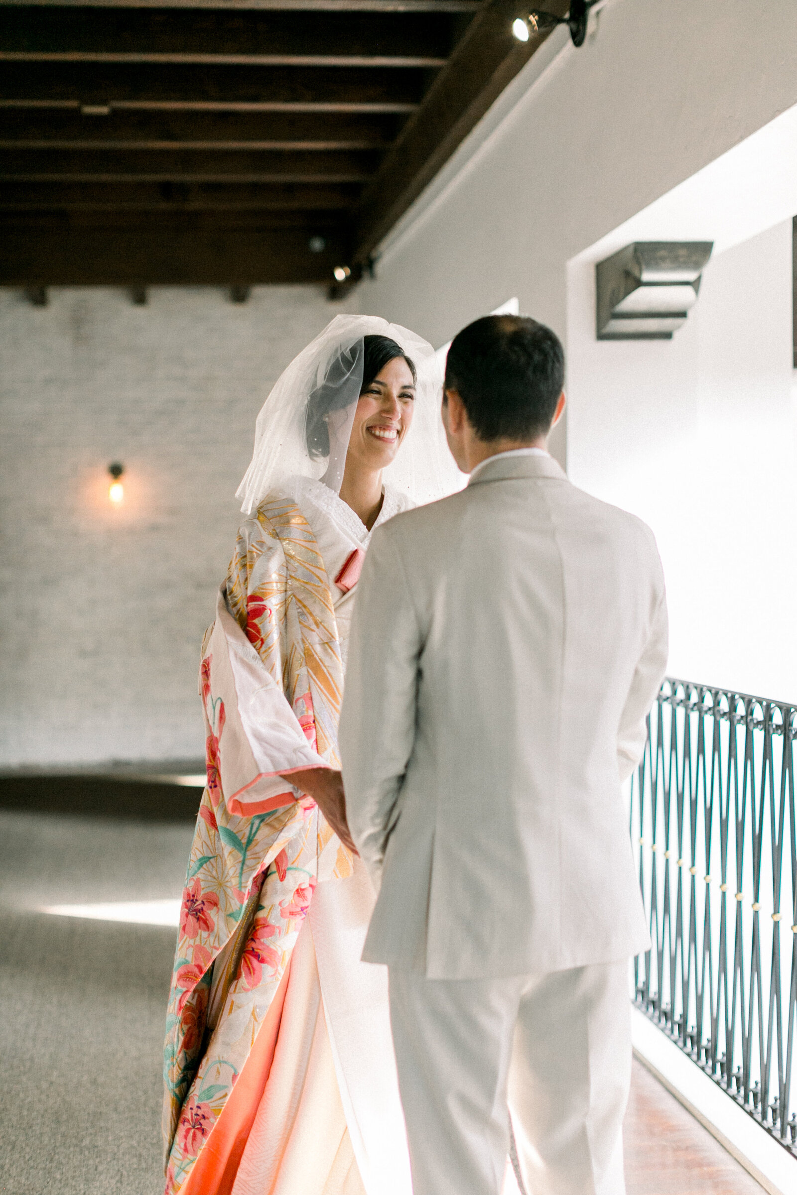 Bride in vibrant floral iro-uchikake and groom sharing a joyful first look at The Ebell Club Long Beach, kimono rental wedding photography in Los Angeles | ロサンゼルスのThe Ebell Club Long Beachで色打掛姿の花嫁と新郎がファーストルックを楽しむ着物レンタル和婚フォト