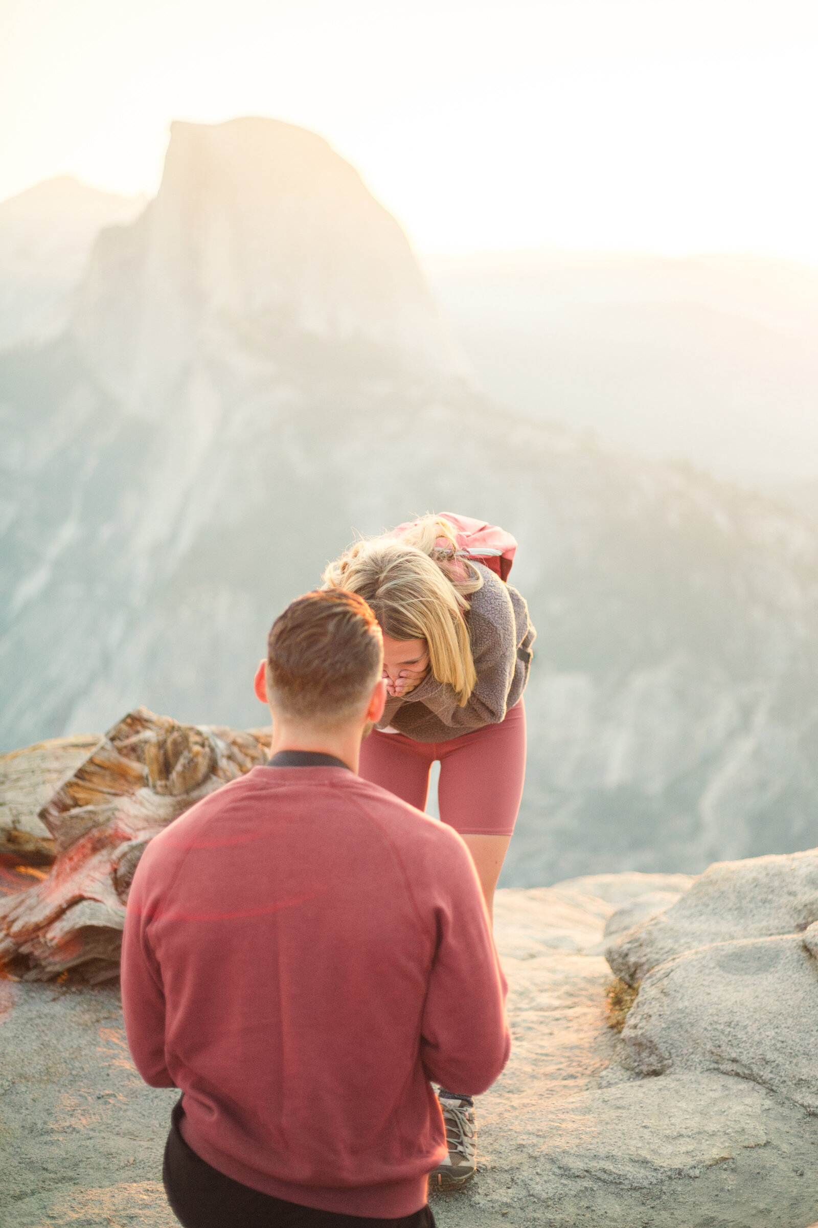A wedding proposal between two hikers at sunrise in front of Half Dome in Yosemite National Park.