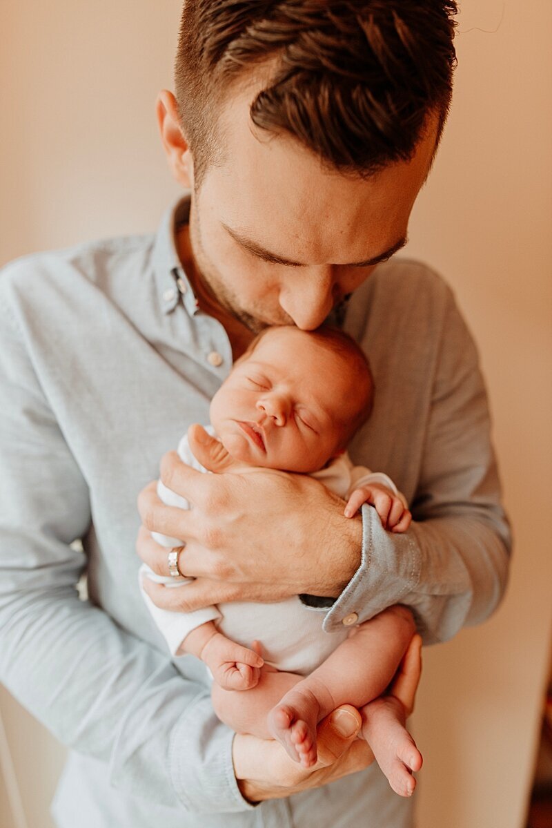 Dad kissing newborns head at Vancouver newborn photography session