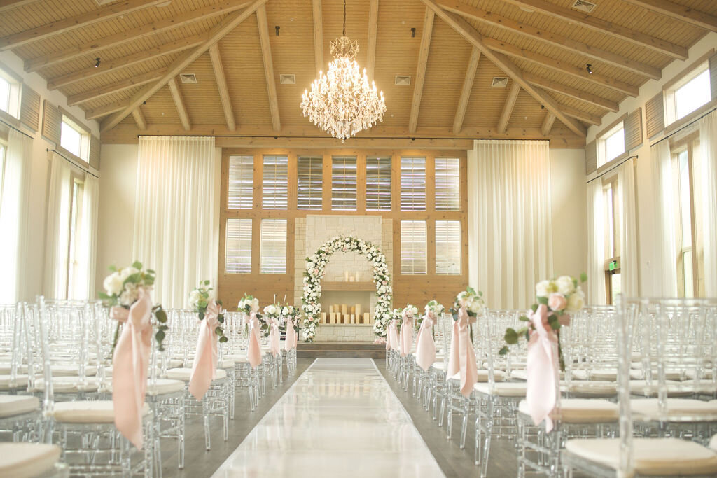 Grand church with high ceiling and pews with pink roses and ribbon and chandelier