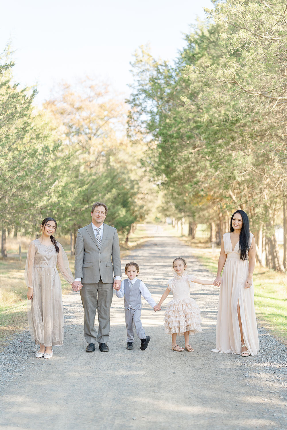 family of 5 posing with rows of trees during Manassas, VA fall minis