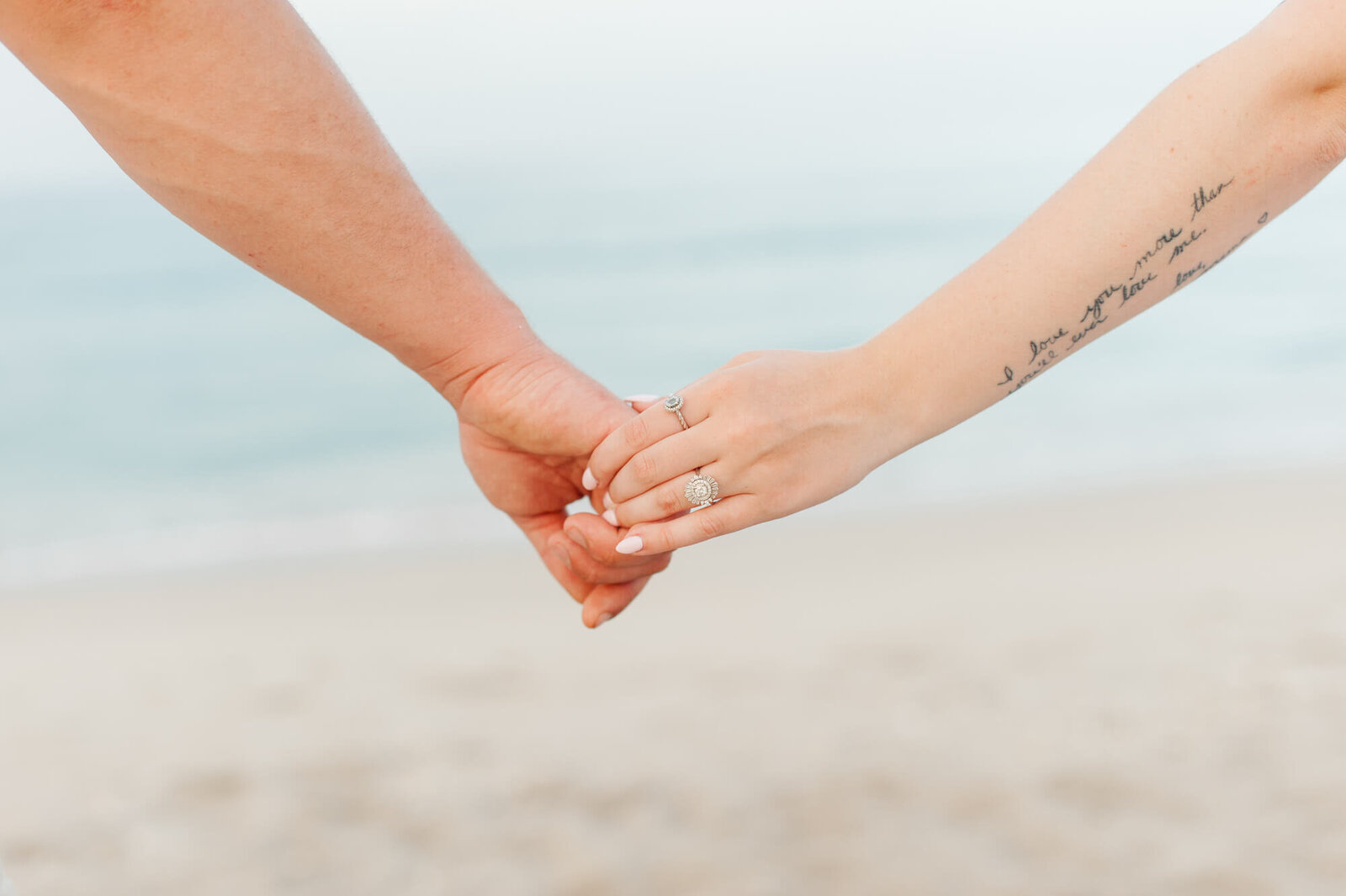 Closeup image of couples holding hands with ring during engagement couples photoshoot