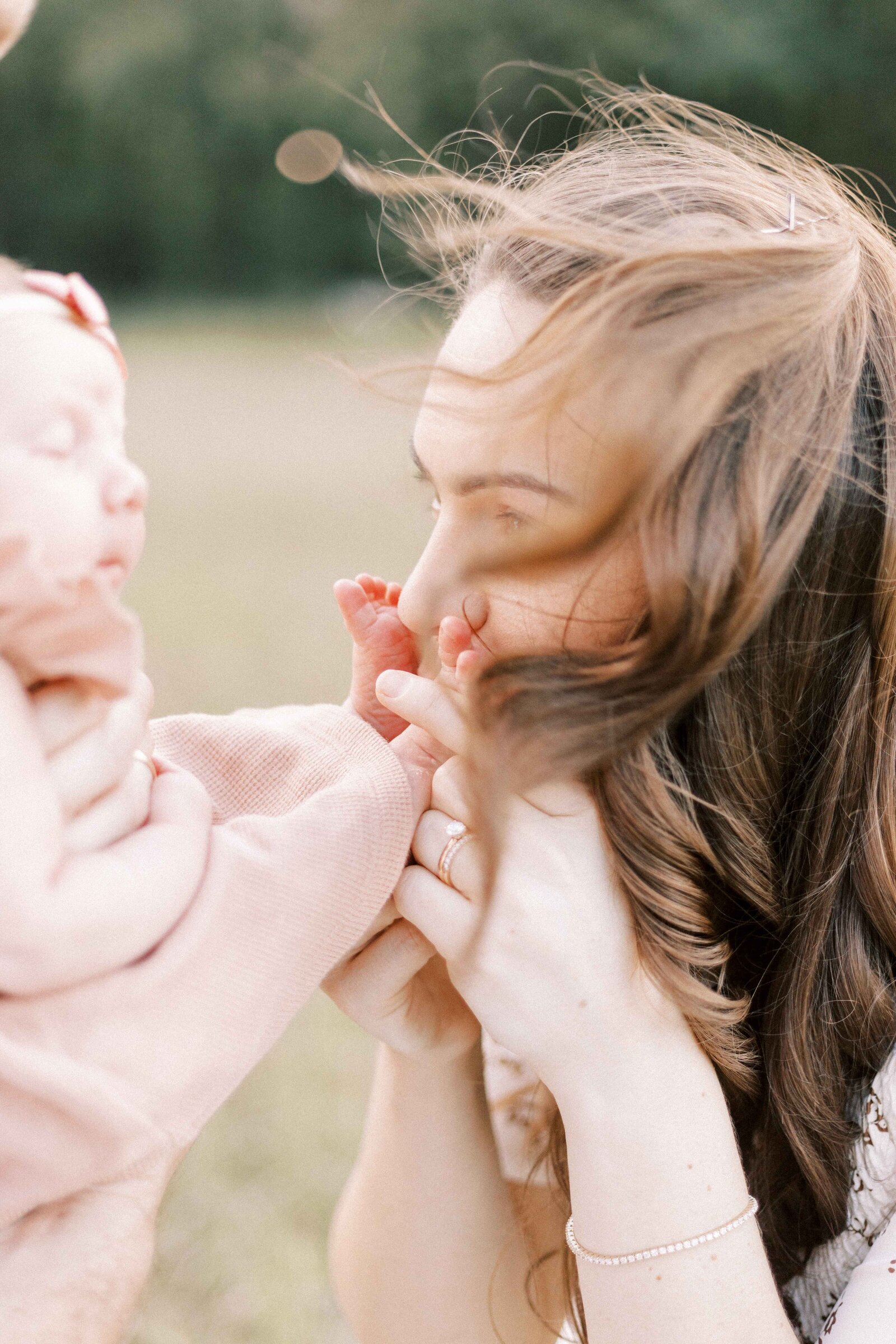 mom kissing baby's feet in newborn session in peoria illinois
