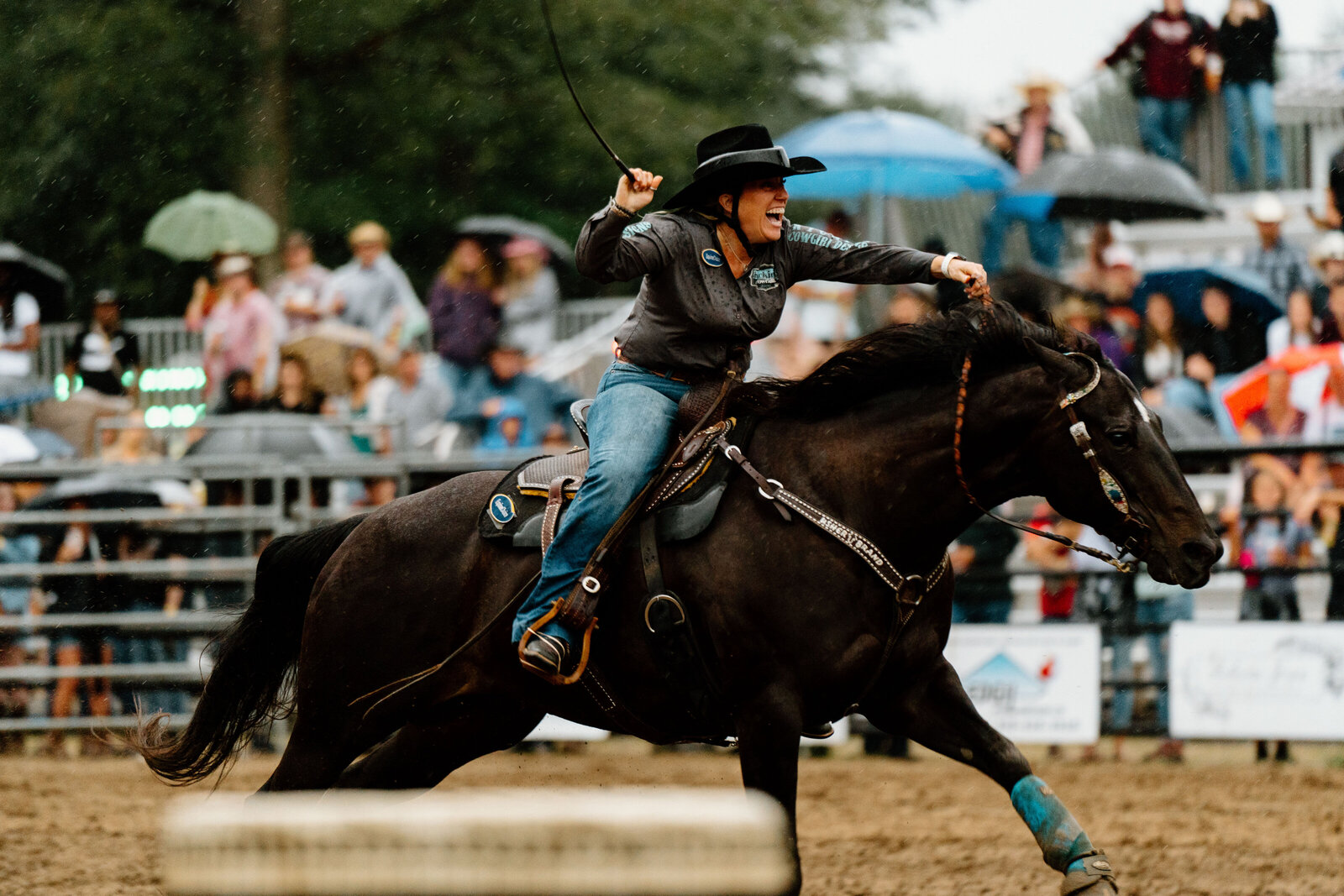 a cowgirl riding her horse in a barrel race at a rodeo
