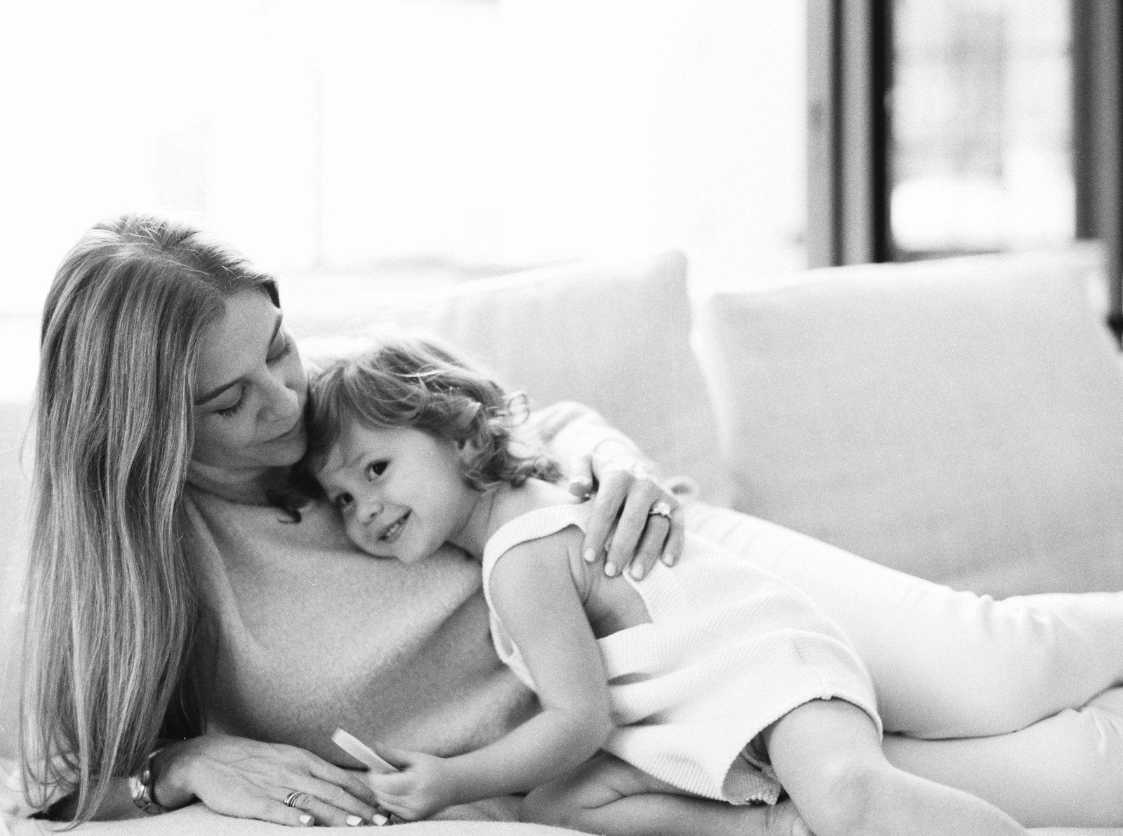 Mom and daughter on the couch smiling for family photograph